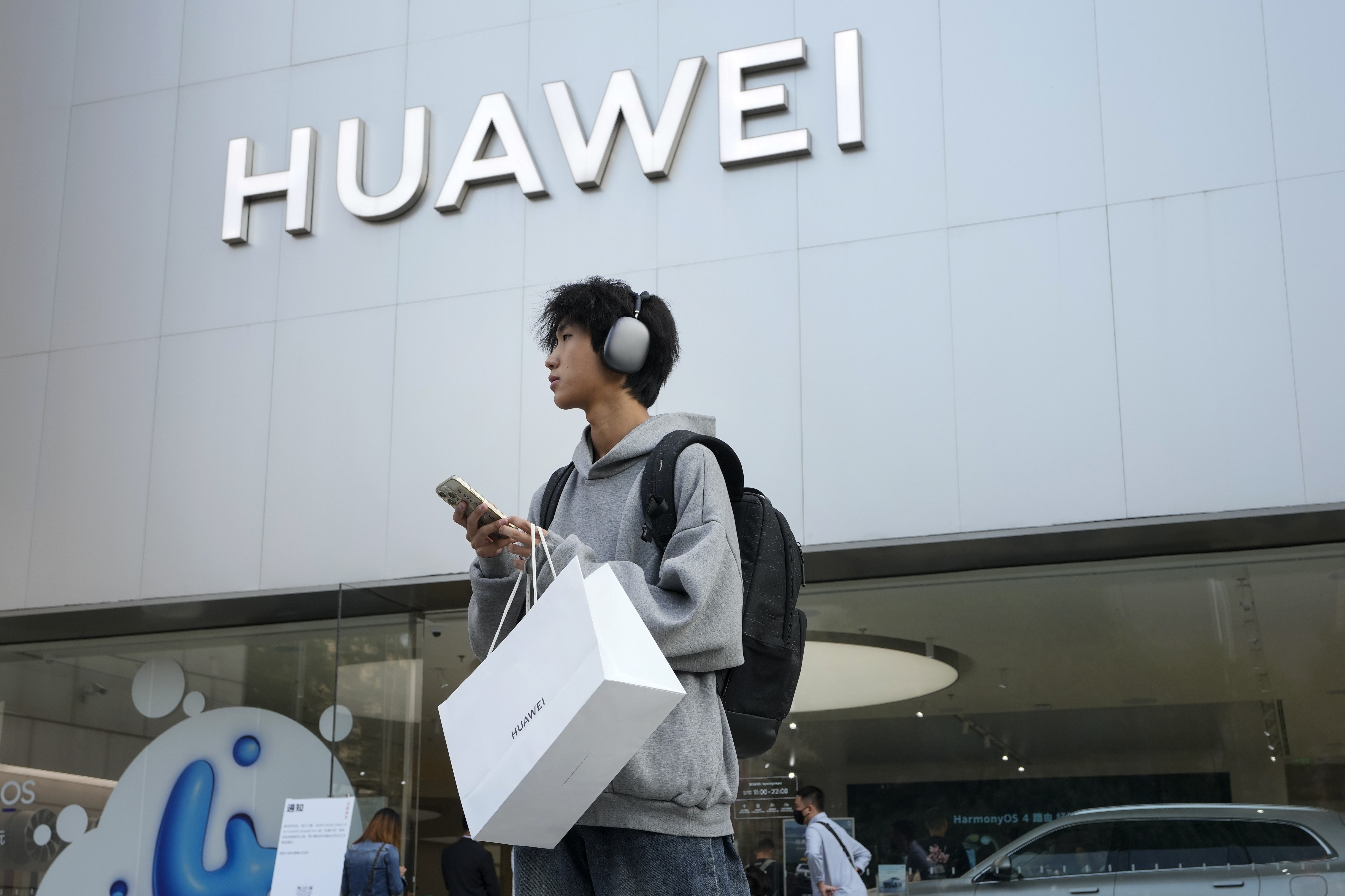 FILE - A customer carries his purchased Huawei product outside a Huawei store after he attended the Huawei new product launch conference in Beijing, on Sept. 25, 2023. (AP Photo/Andy Wong, File)