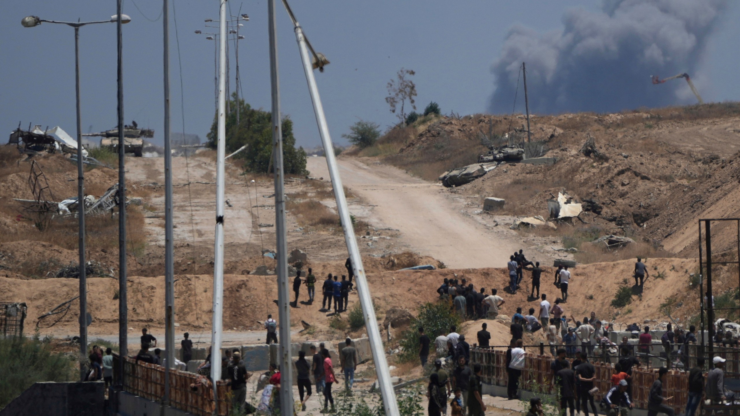 FILE - Israeli army tanks are seen positioned as smoke rises in the background in southern Gaza, as seen from a humanitarian aid distribution center operated by the U.S.-backed Gaza Humanitarian Foundation, approved by Israel, in Khan Younis, southern Gaza Strip, on Thursday, May 29, 2025. (AP Photo/Abdel Kareem Hana,File)