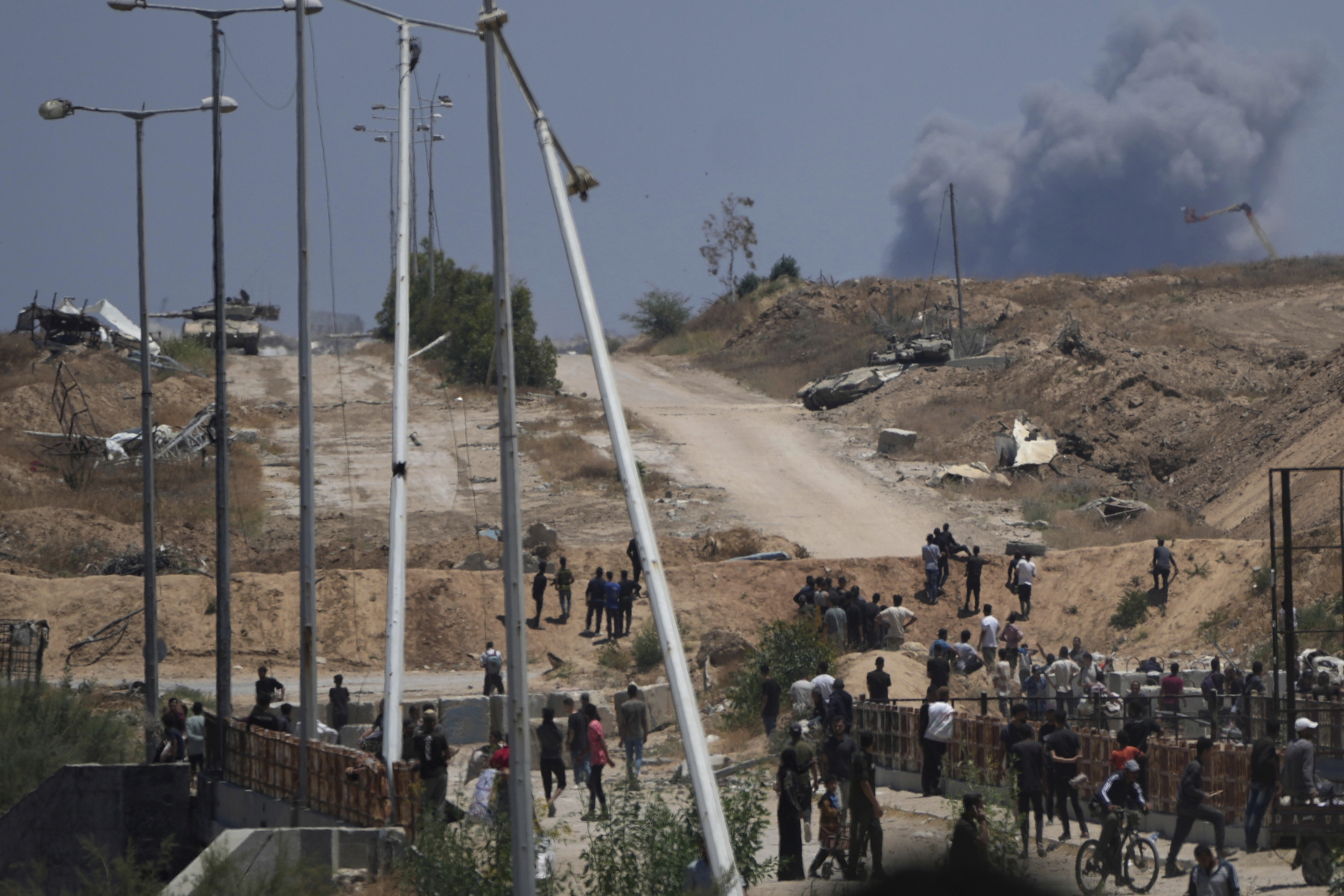 FILE - Israeli army tanks are seen positioned as smoke rises in the background in southern Gaza, as seen from a humanitarian aid distribution center operated by the U.S.-backed Gaza Humanitarian Foundation, approved by Israel, in Khan Younis, southern Gaza Strip, on Thursday, May 29, 2025. (AP Photo/Abdel Kareem Hana,File)
