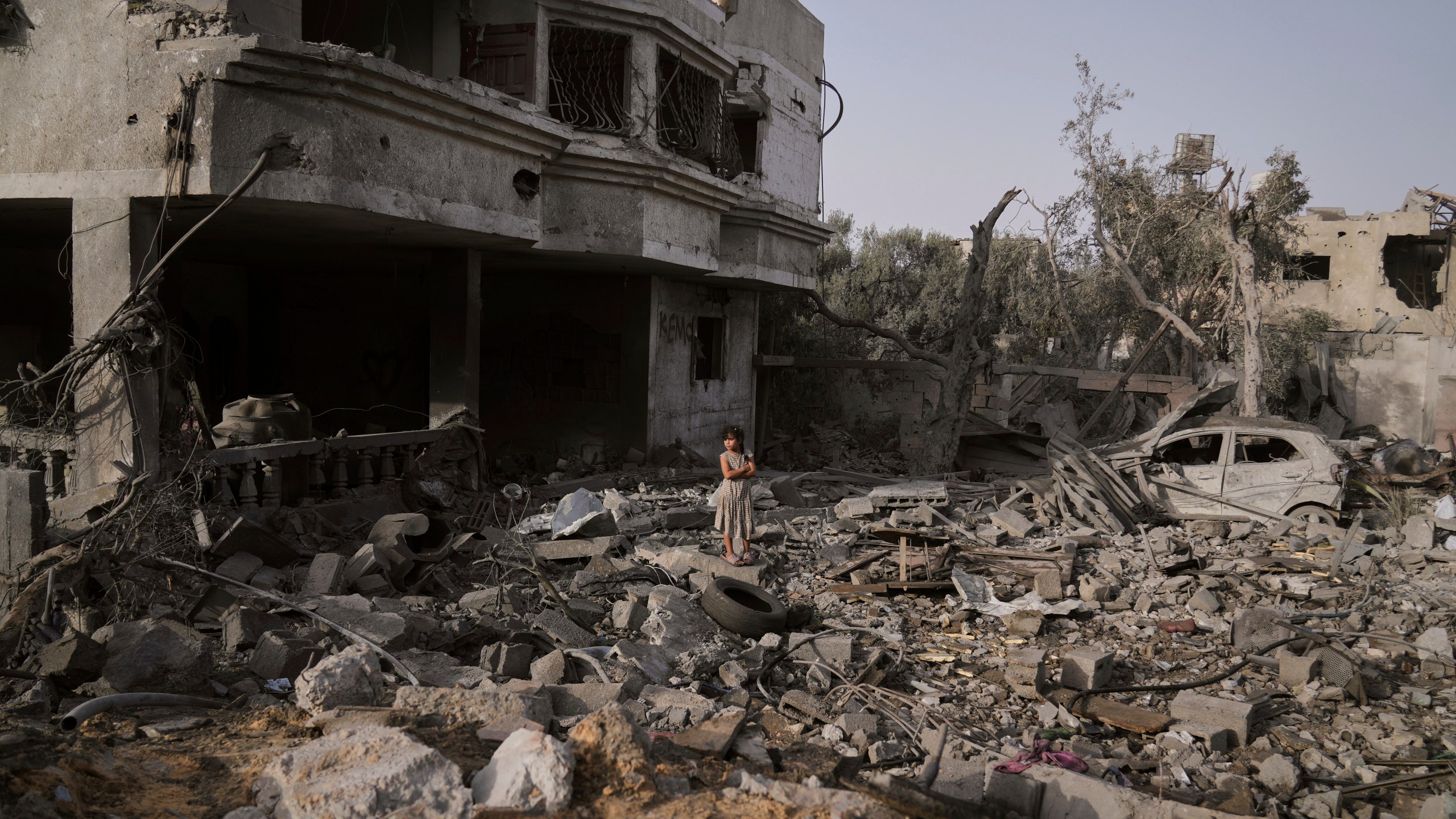 A Palestinian girl stands atop the rubble of the Al-Aimawi family's home that was destroyed by Israeli airstrikes in Al-Zawaideh, Gaza Strip, Tuesday, July 1, 2025. (AP Photo/Abdel Kareem Hana)