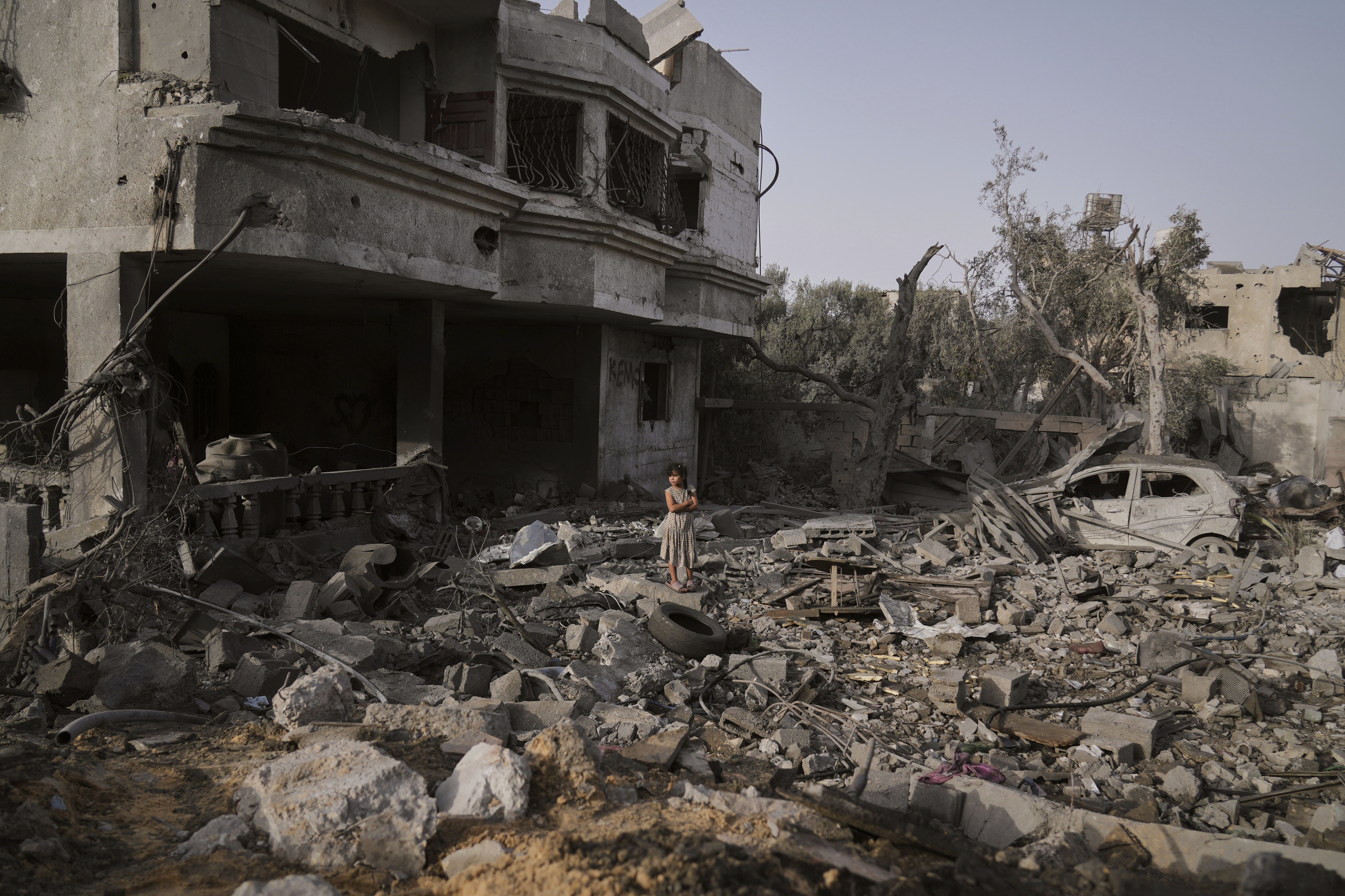 A Palestinian girl stands atop the rubble of the Al-Aimawi family's home that was destroyed by Israeli airstrikes in Al-Zawaideh, Gaza Strip, Tuesday, July 1, 2025. (AP Photo/Abdel Kareem Hana)
