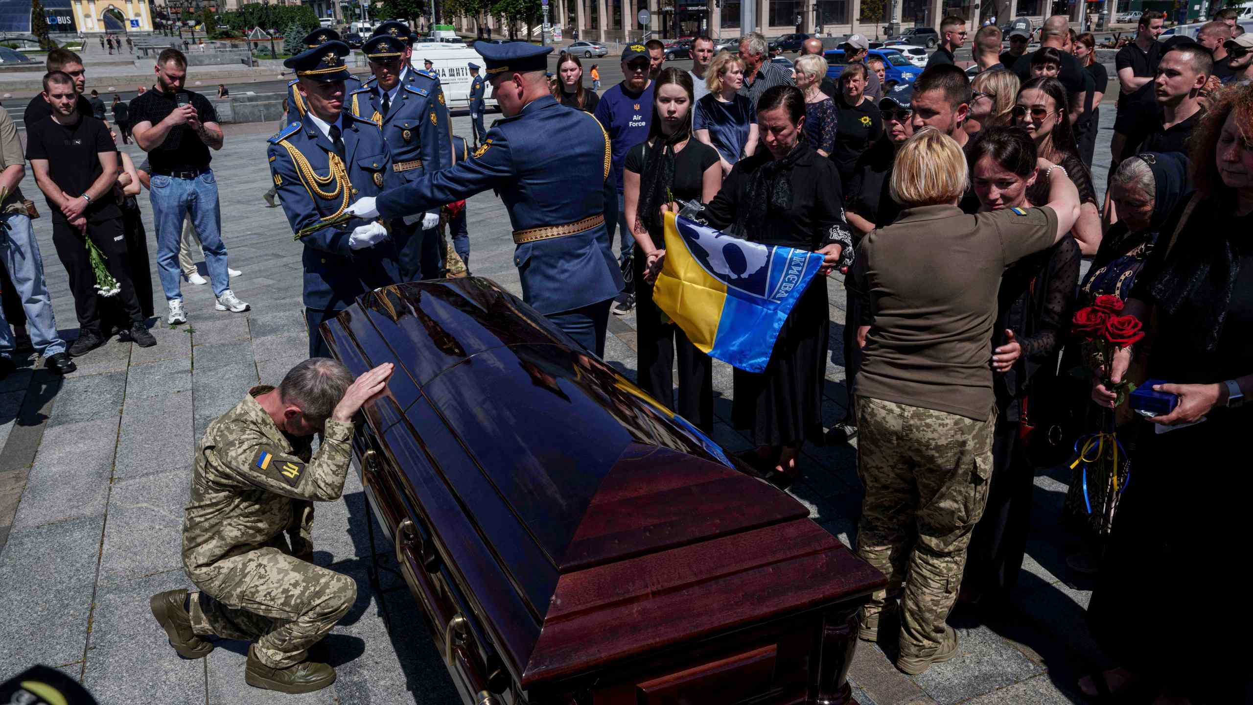 A Ukrainian serviceman says goodbye to Ukrainian F-16 pilot Maksym Ustymenko, during a farewell ceremony in Kyiv, Ukraine, on Thursday, July 3, 2025. (AP Photo/Evgeniy Maloletka)