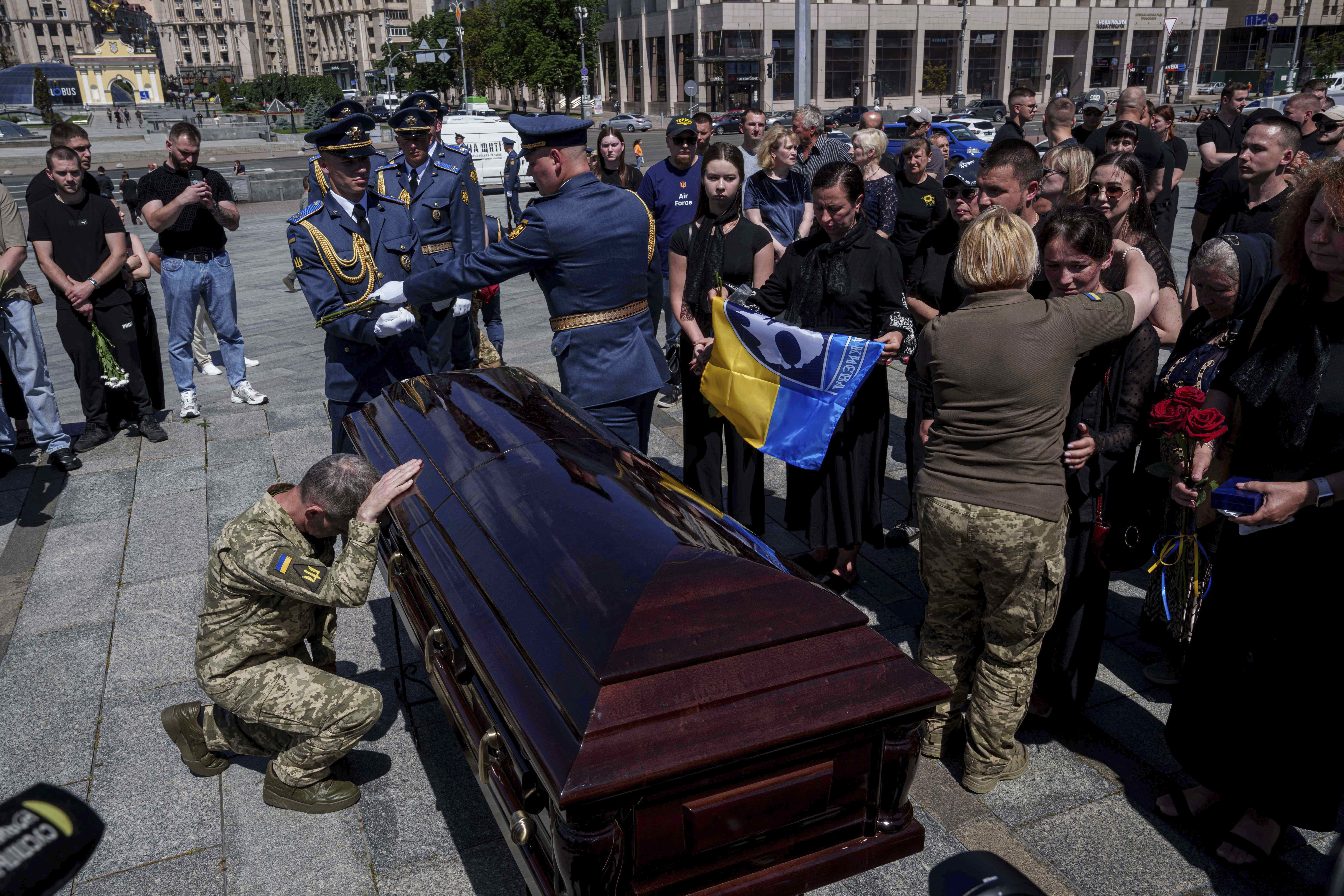 A Ukrainian serviceman says goodbye to Ukrainian F-16 pilot Maksym Ustymenko, during a farewell ceremony in Kyiv, Ukraine, on Thursday, July 3, 2025. (AP Photo/Evgeniy Maloletka)