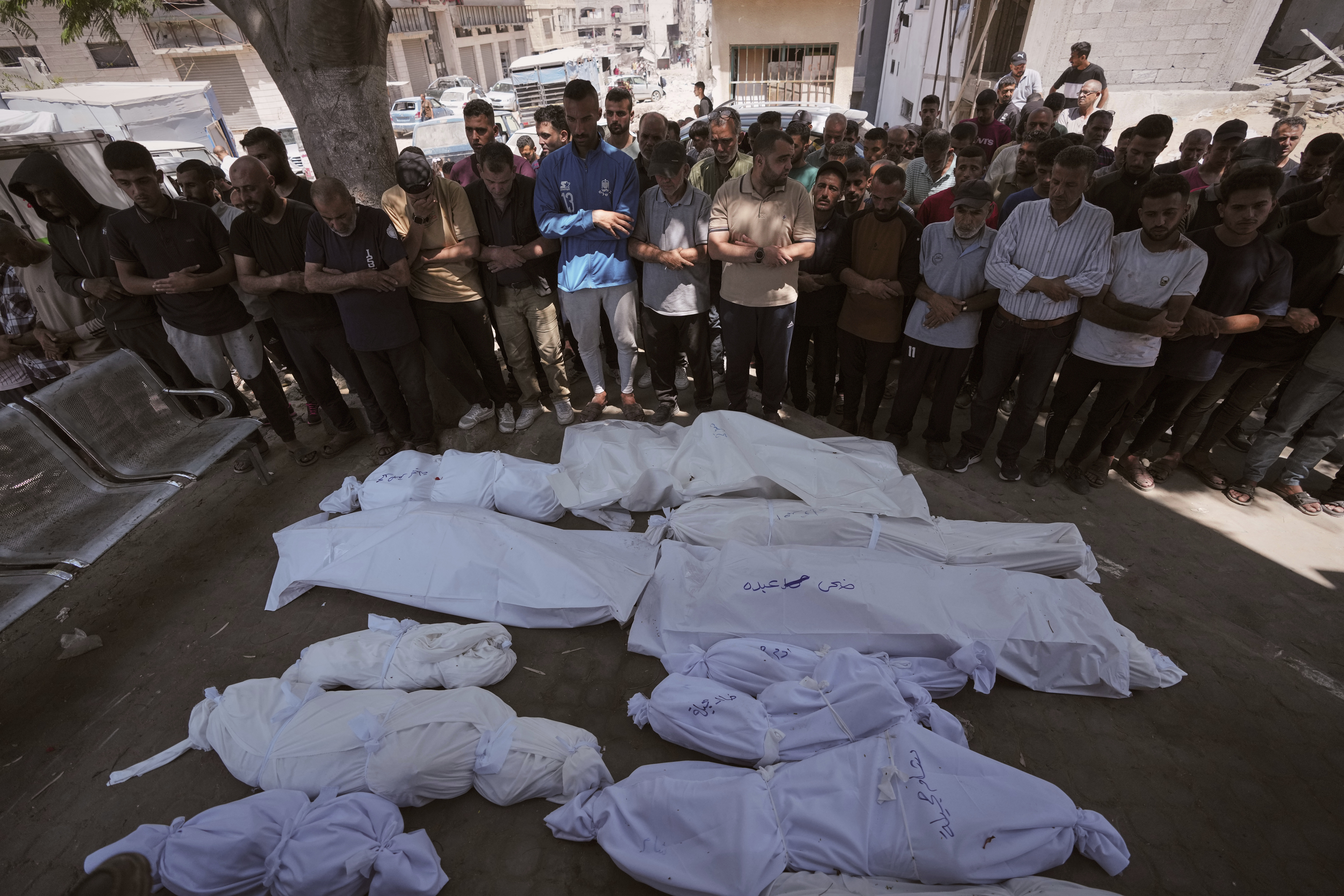 Mourners pray beside the bodies of Palestinians that were killed by an Israeli airstrike that struck a school used as a shelter, in Shifa Hospital in Gaza City, on Thursday, July 3, 2025. (AP Photo/Jehad Alshrafi)