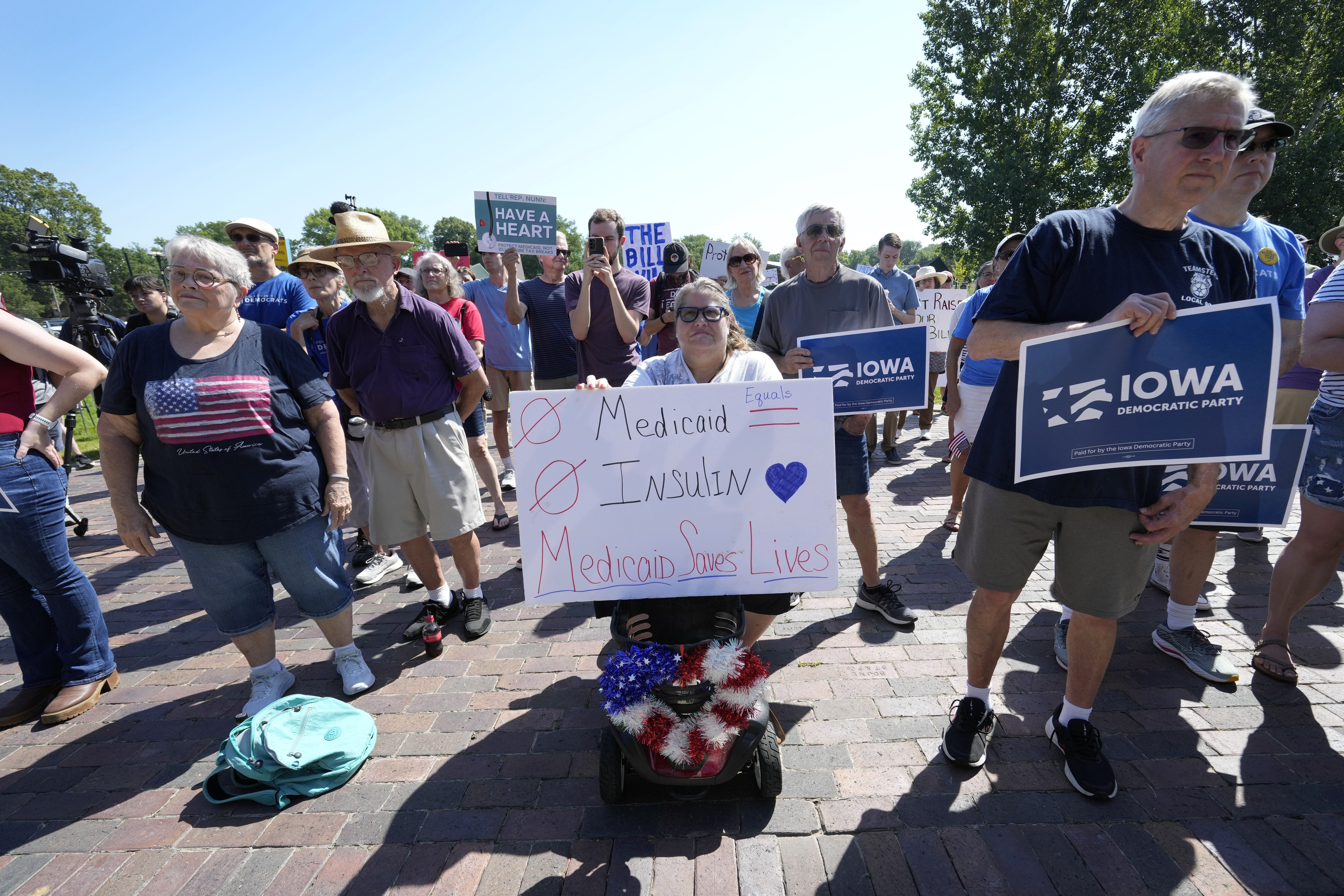 Local residents listen to a speech during an Iowa Democratic Party rally, Thursday, July 3, 2025, in Windsor Heights, Iowa. (AP Photo/Charlie Neibergall)