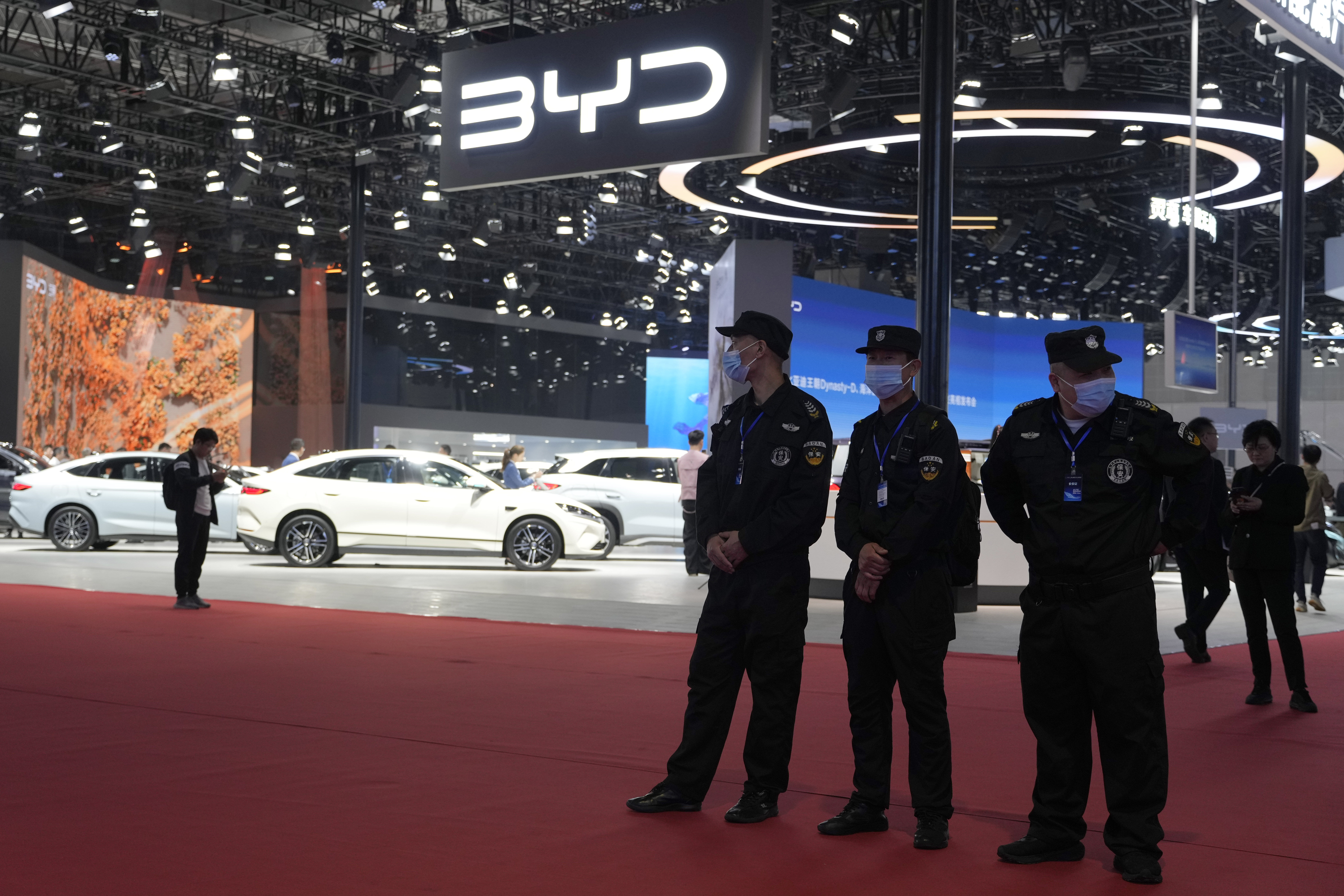 Security personnel on duty stand near the BYD booth during the Shanghai auto show, April 23, 2025. (AP Photo/Ng Han Guan)