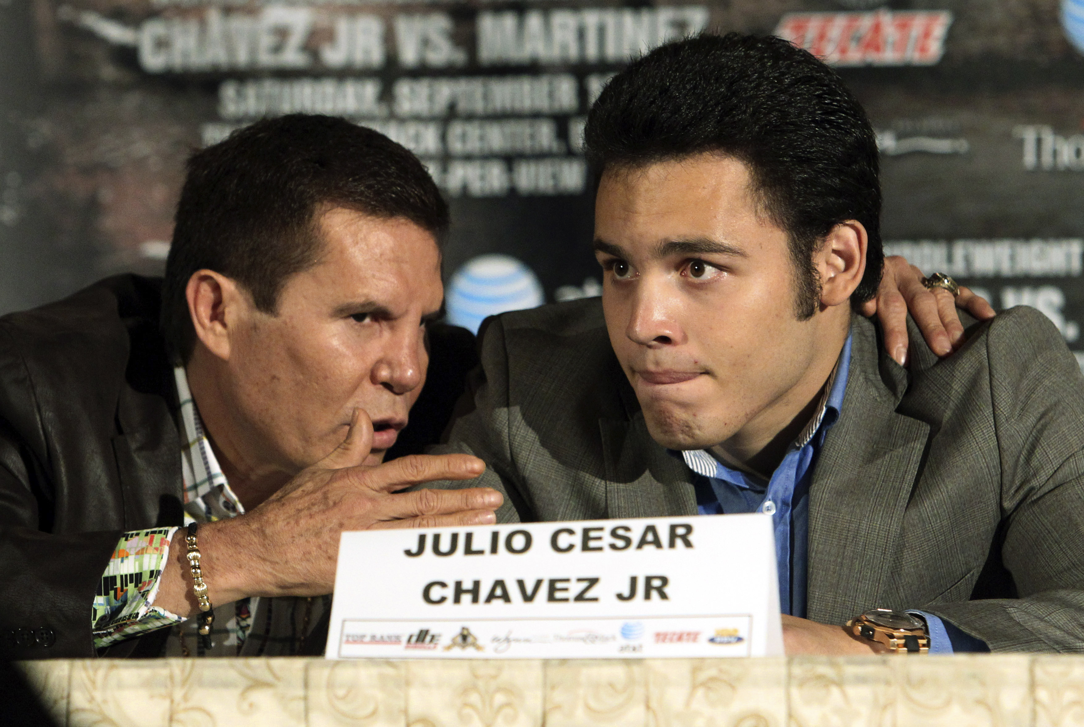 FILE - Julio Cesar Chavez Jr., right, of Mexico, talks with his father, legendary boxer Julio Cesar Chavez, left, at a news conference to promote his upcoming middleweight championship boxing match with Sergio Martinez, of Argentina, in Los Angeles, July 10, 2012. (AP Photo/Reed Saxon, File)