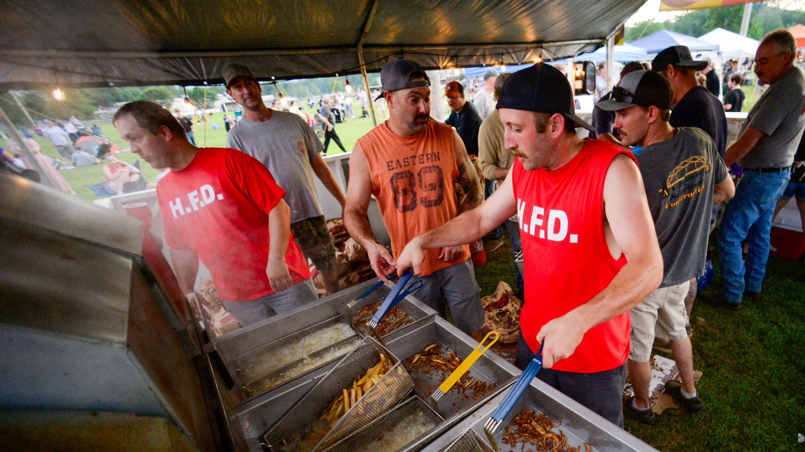Members of the Hinsdale, N.H., Fire Department make fresh fries during the annual fireworks show on Thursday, July 3, 2025. (Kristopher Radder/The Brattleboro Reformer via AP)