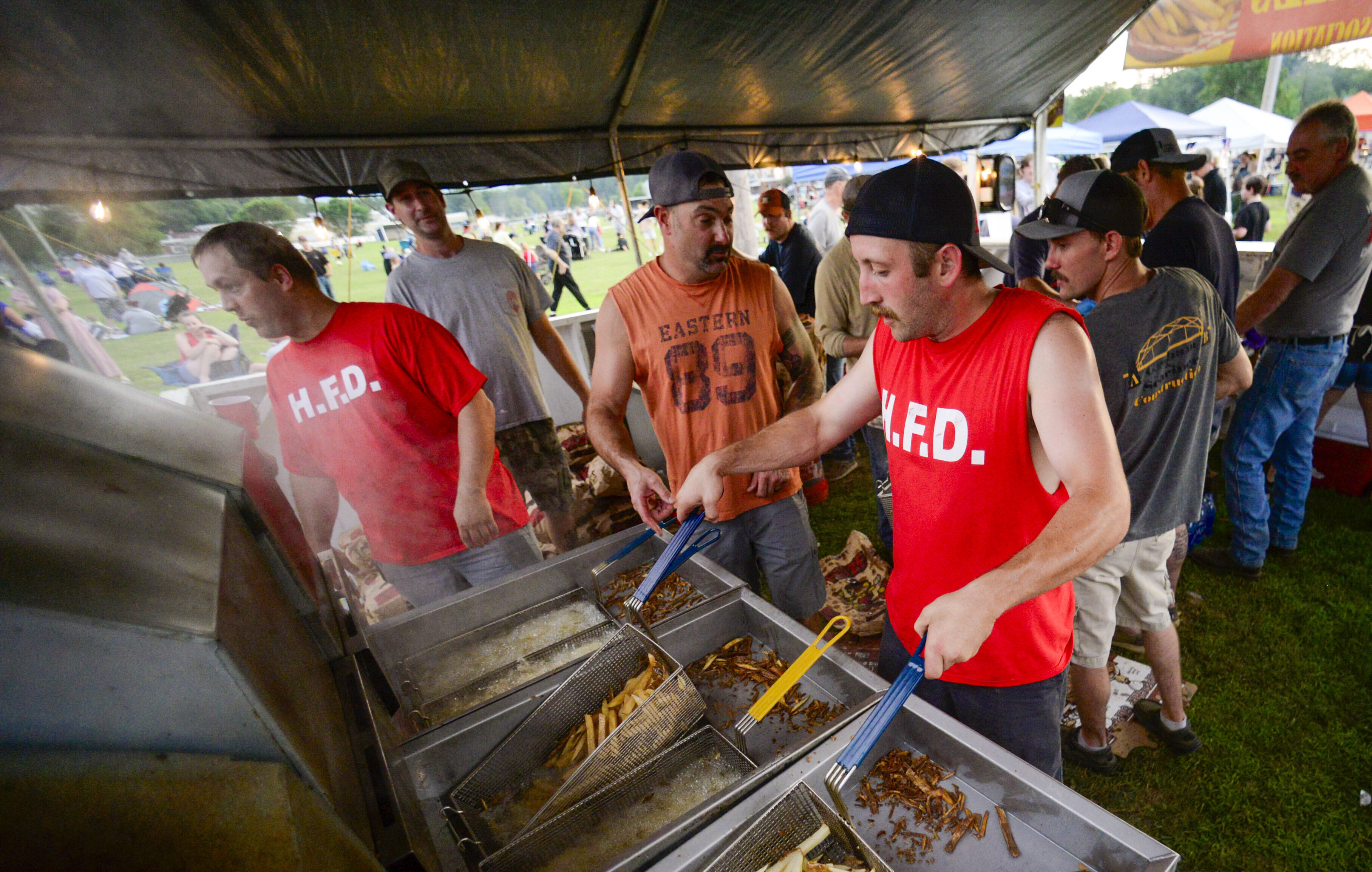 Members of the Hinsdale, N.H., Fire Department make fresh fries during the annual fireworks show on Thursday, July 3, 2025. (Kristopher Radder/The Brattleboro Reformer via AP)