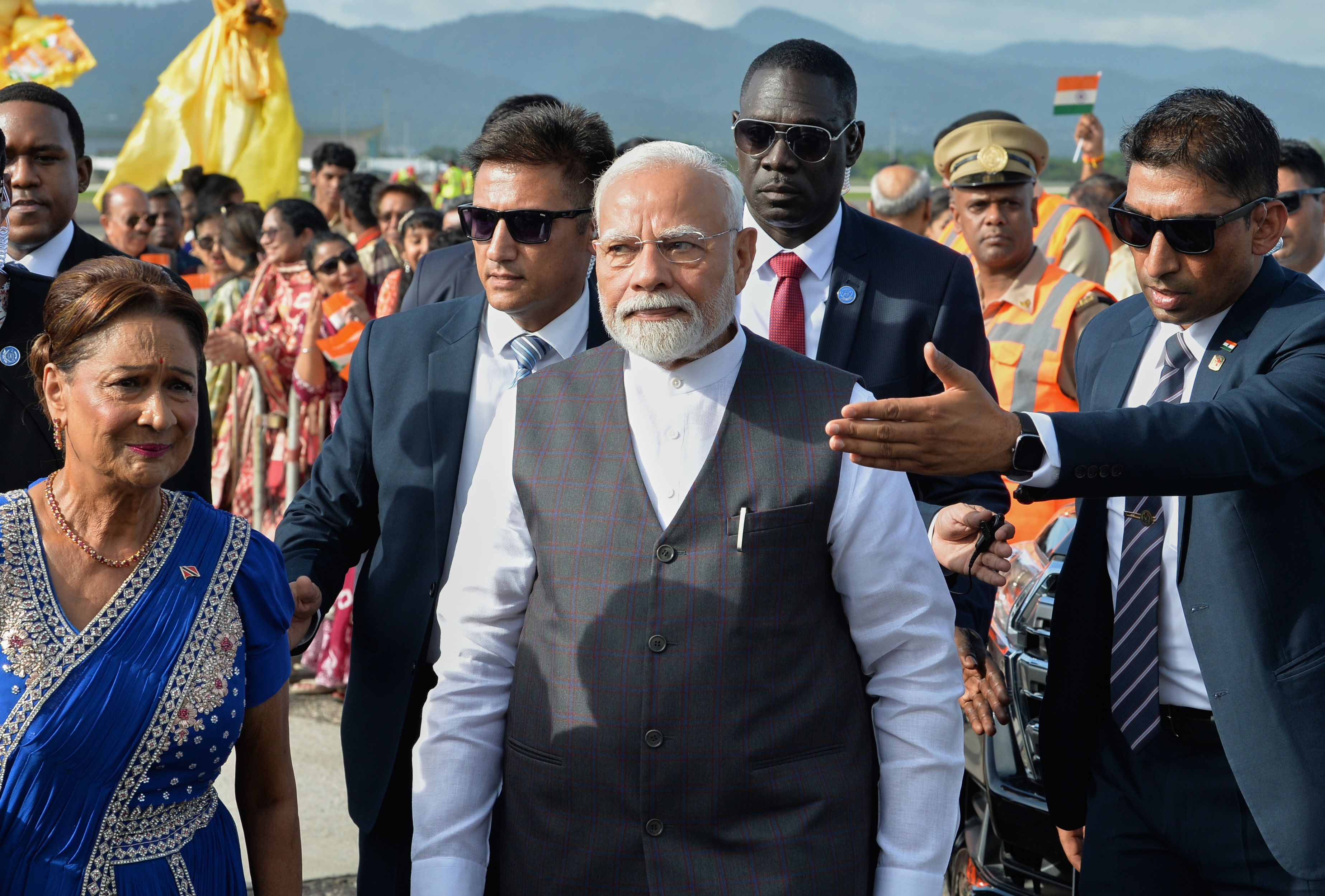 India's Prime Minister Narendra Modi, center, walks with Trinidad and Tobago Prime Minister Kamla Persad-Bissessar, dressed in traditional Indian attire, left, upon his arrival at Piarco International Airport in Piarco, Trinidad and Tobago, Thursday, July 3, 2025. (AP Photo/Jermaine Cruickshank)