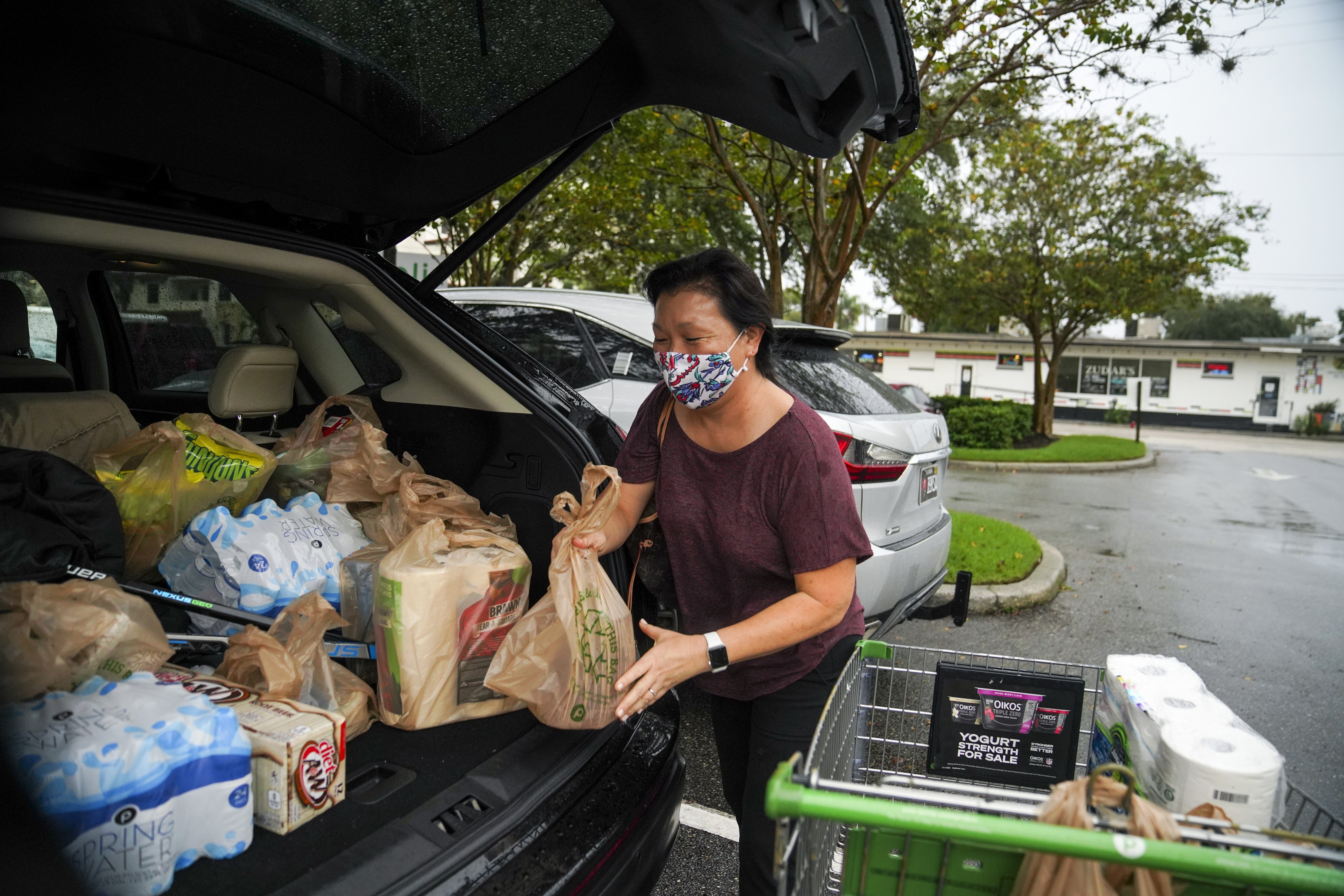 FILE - Leslie Crowell loads water, paper towels and other groceries into her car Wednesday, Nov. 11, 2020 at Publix in preparation for Tropical Storm Eta in Tampa, Fla. (Martha Asencio Rhine/Tampa Bay Times via AP,File)