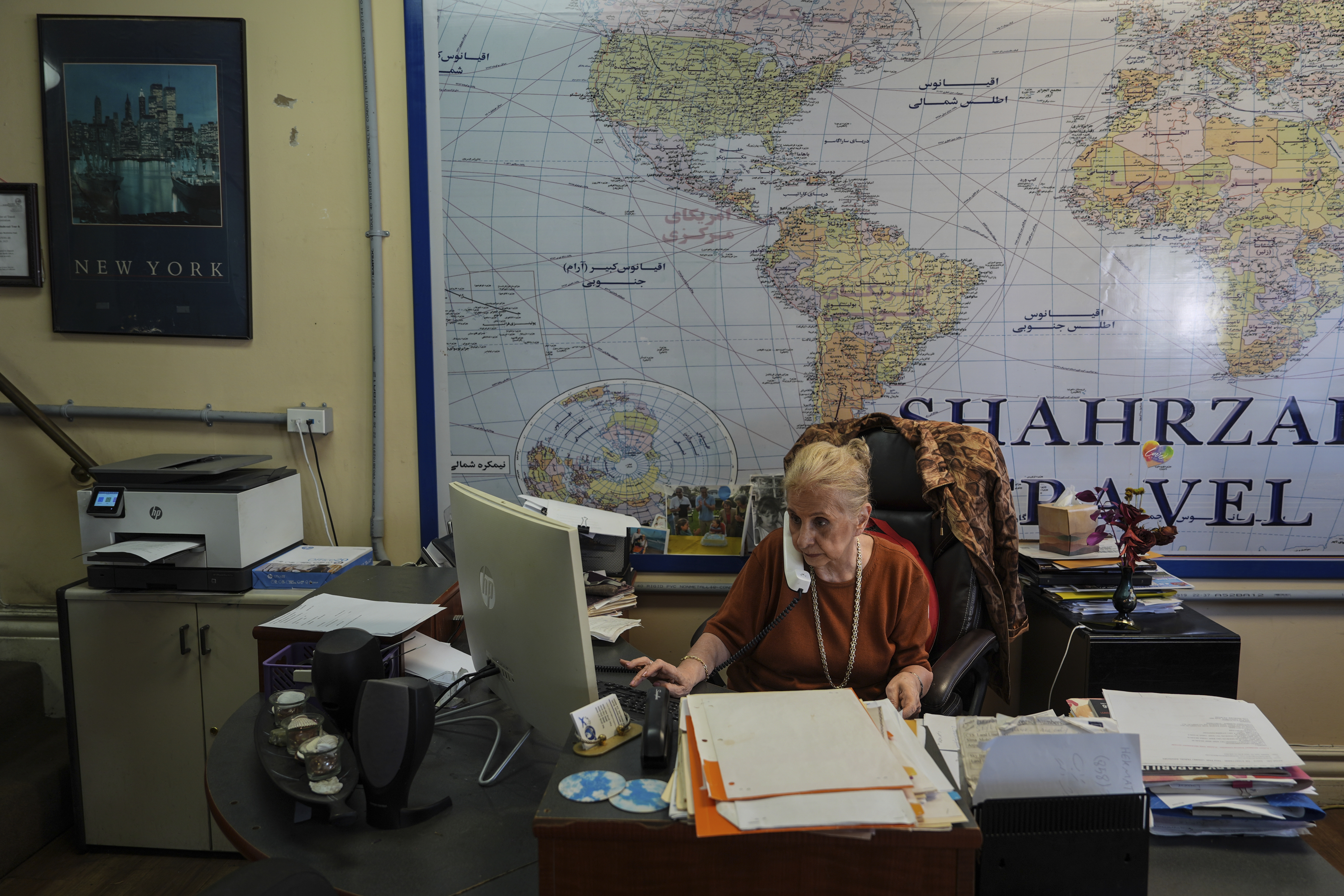 Shahrzad Tahouri works at her travel agency in the "Tehrangeles" neighborhood of Los Angeles Tuesday, June 24, 2025. (AP Photo/Jae C. Hong)