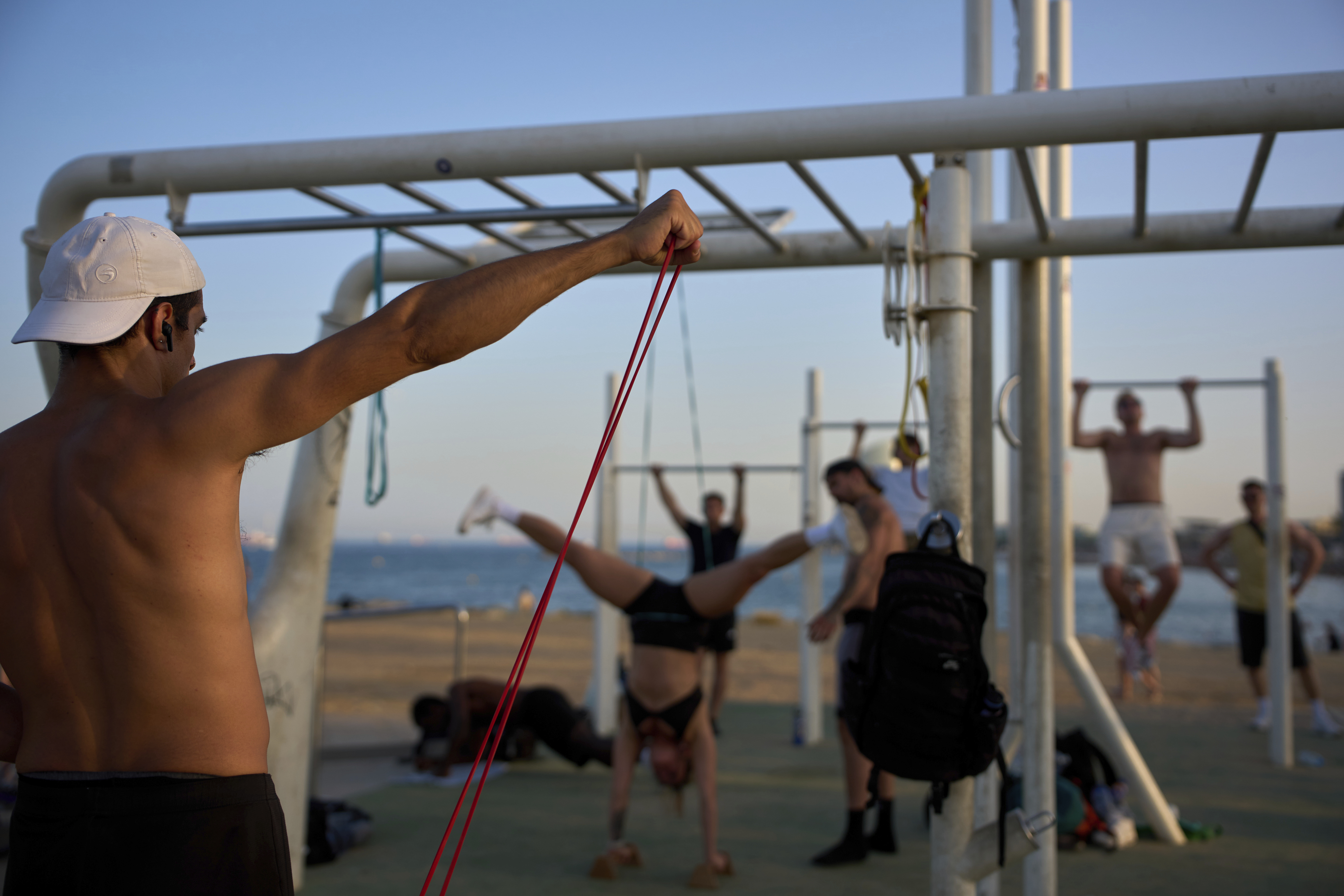 People work out in an open-air gym next to the beach in Barcelona, Spain, Tuesday, June 25, 2025. (AP Photo/Emilio Morenatti)