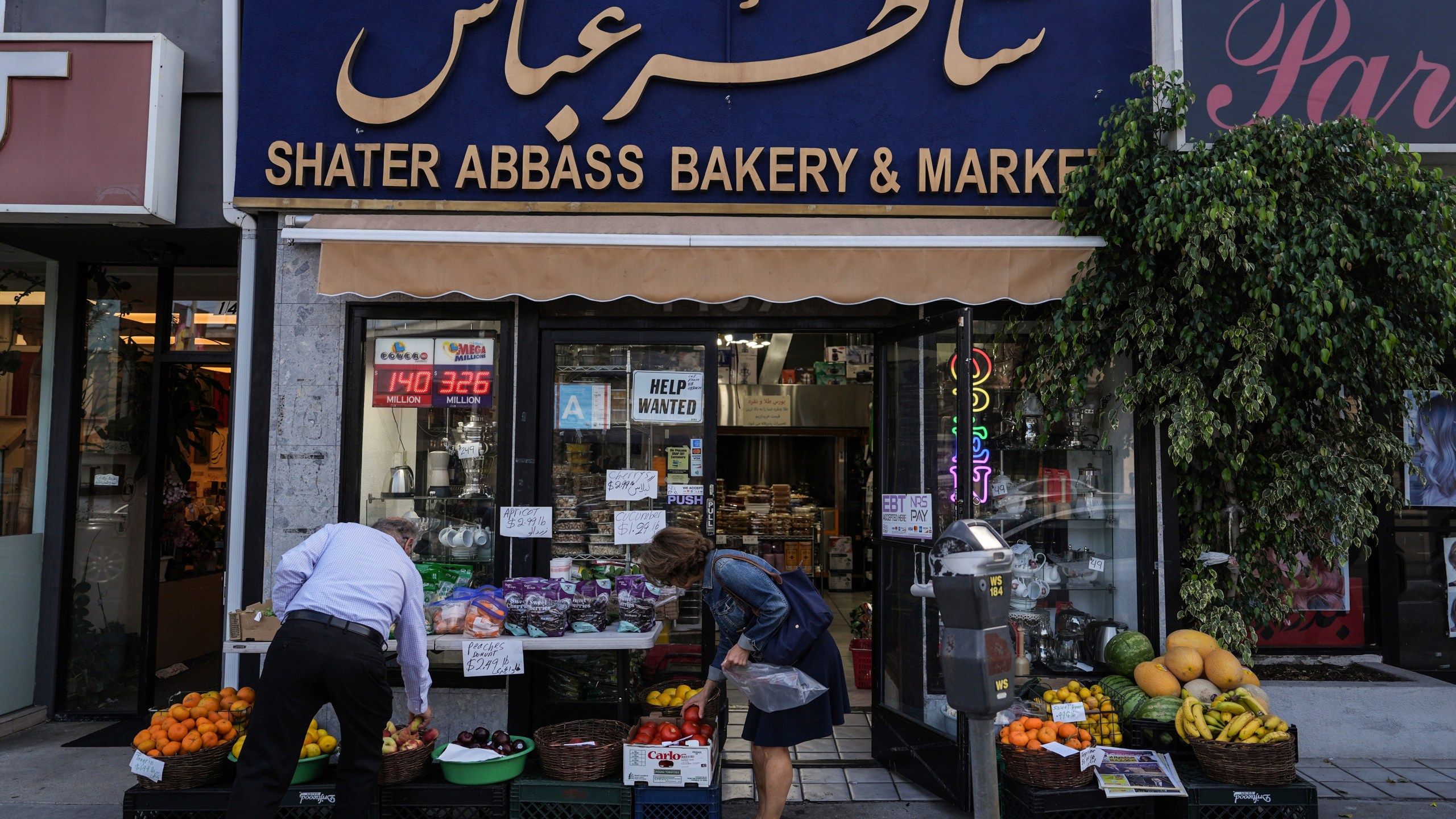 Two shoppers select items at a grocery store in the "Tehrangeles" neighborhood of Los Angeles Tuesday, June 24, 2025. (AP Photo/Jae C. Hong)