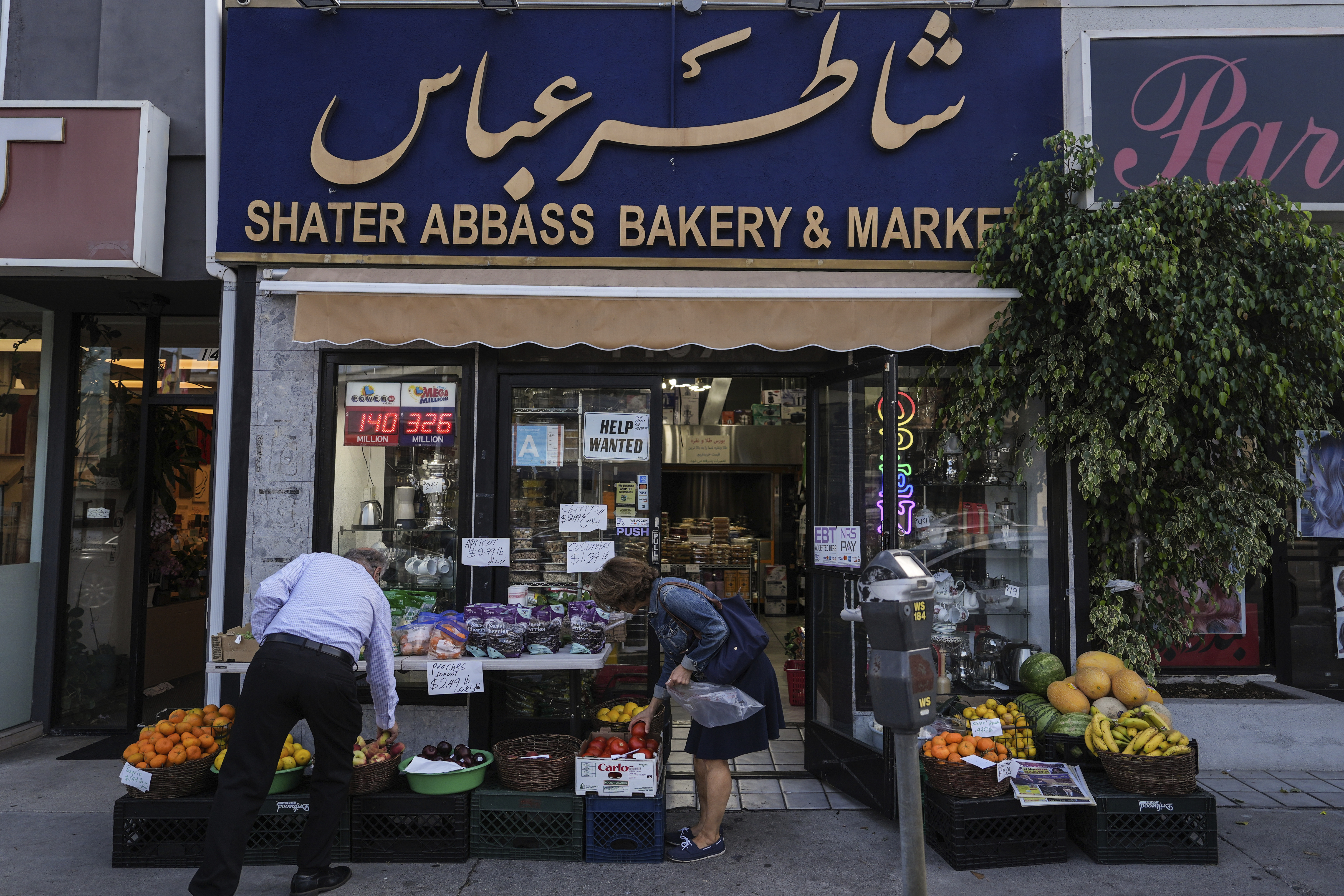 Two shoppers select items at a grocery store in the "Tehrangeles" neighborhood of Los Angeles Tuesday, June 24, 2025. (AP Photo/Jae C. Hong)