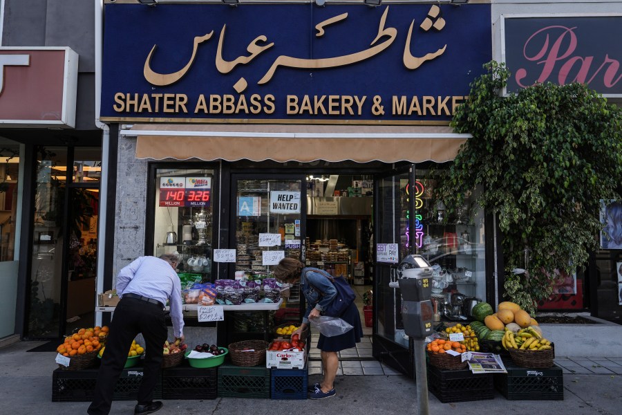 Two shoppers select items at a grocery store in the "Tehrangeles" neighborhood of Los Angeles Tuesday, June 24, 2025. (AP Photo/Jae C. Hong)