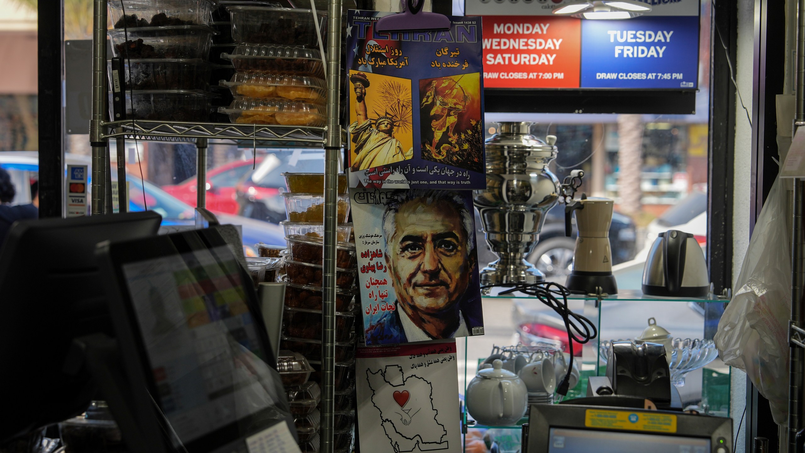 Persian-language magazines are displayed near the register of a grocery store in the "Tehrangeles" neighborhood of Los Angeles Tuesday, June 24, 2025. (AP Photo/Jae C. Hong)