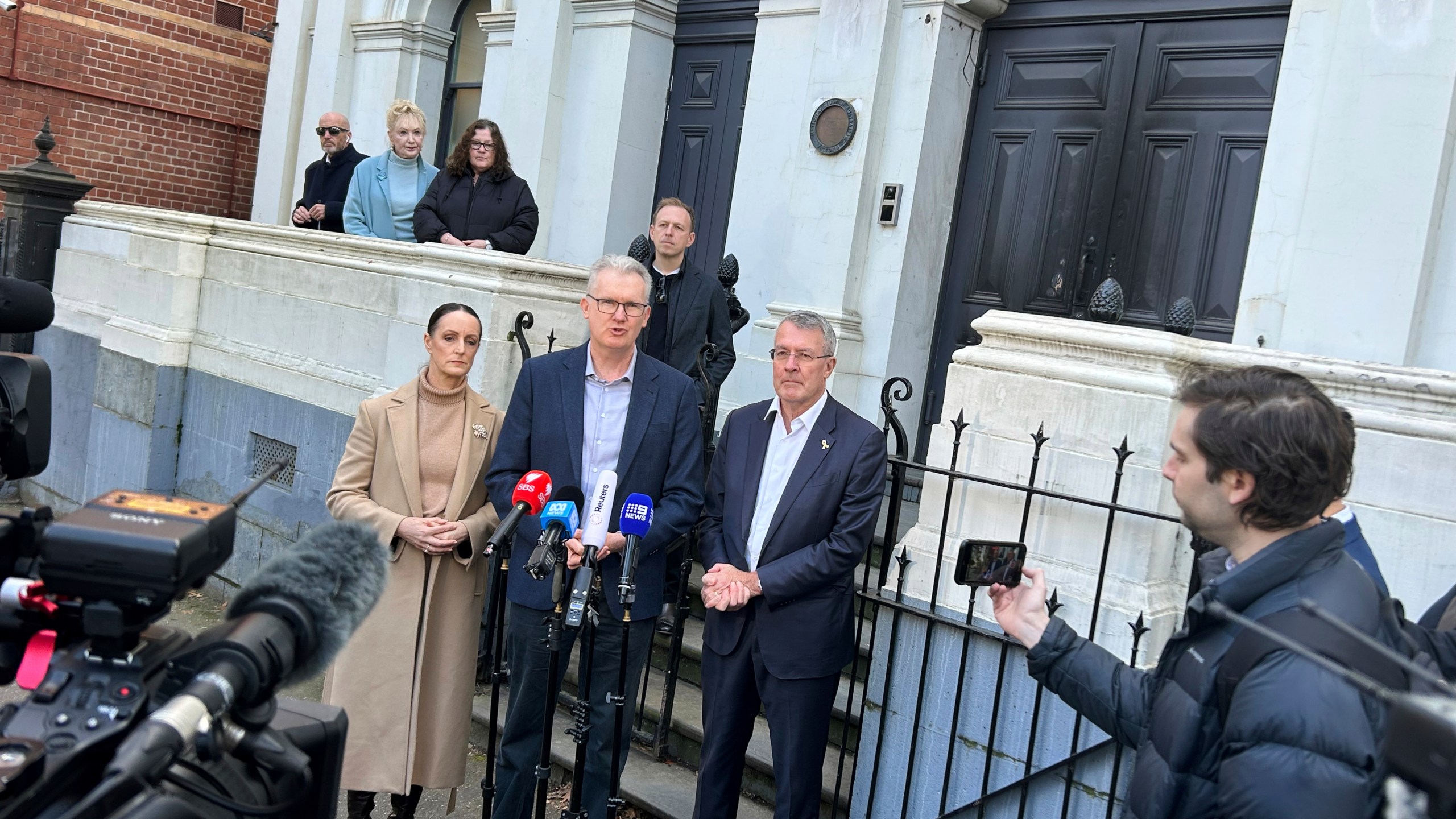 Australian government lawmaker Sarah Witty, center left, Home Affairs Minister Tony Burke, center, and Jewish government lawmaker Mark Dreyfus, center right, address the media outside the East Melbourne Synagogue in Melbourne, Australia Sunday, July 6, 2025, after someone set fire to the synagogue's front door two days earlier. (AP Photo/Rod McGuirk)