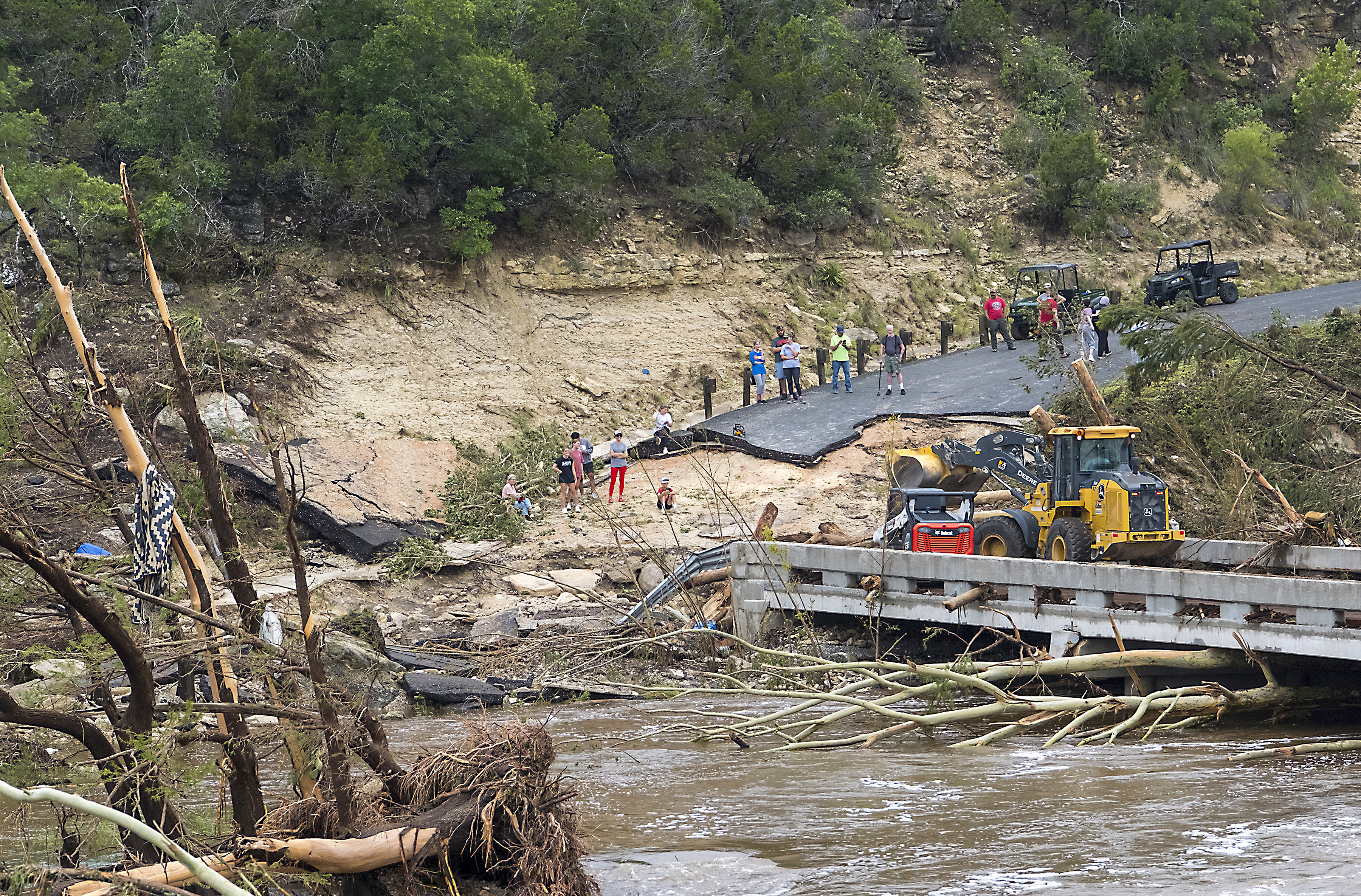 Crews work to clear debris from the Cade Loop bridge along the Guadalupe River on Saturday, July 5, 2025, in Ingram, Texas. (AP Photo/Rodolfo Gonzalez)