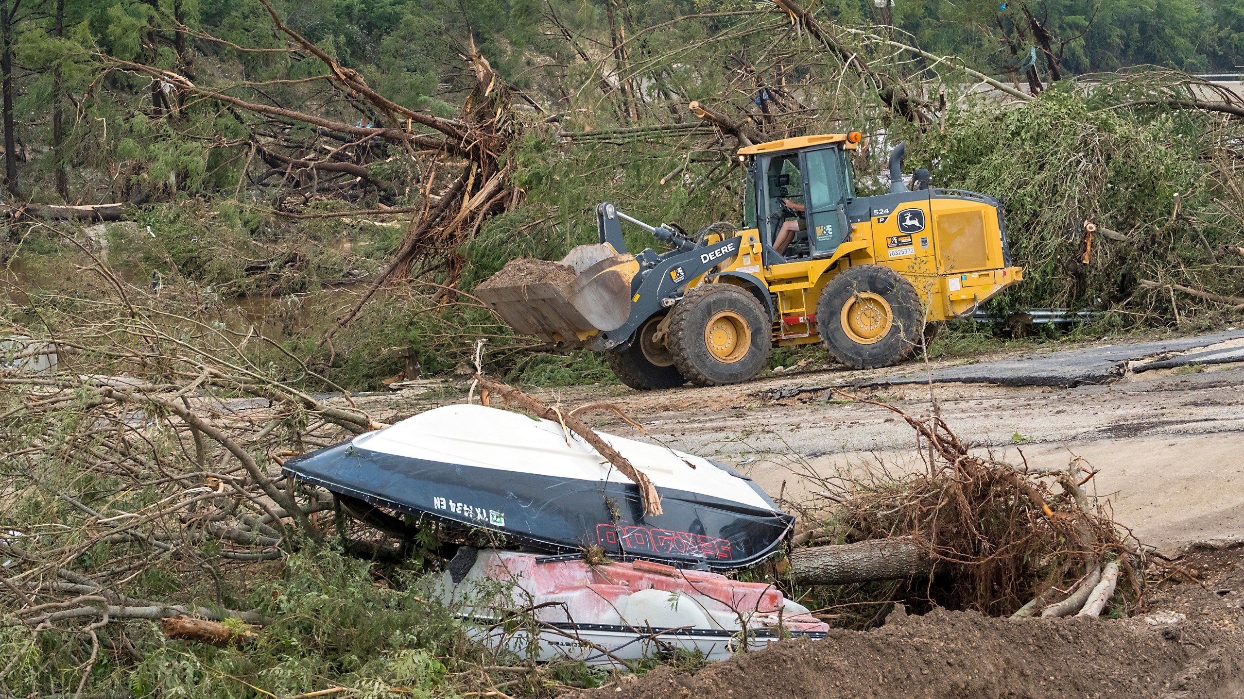 Crews work to clear debris from the Cade Loop bridge along the Guadalupe River on Saturday, July 5, 2025, in Ingram, Texas. (AP Photo/Rodolfo Gonzalez)