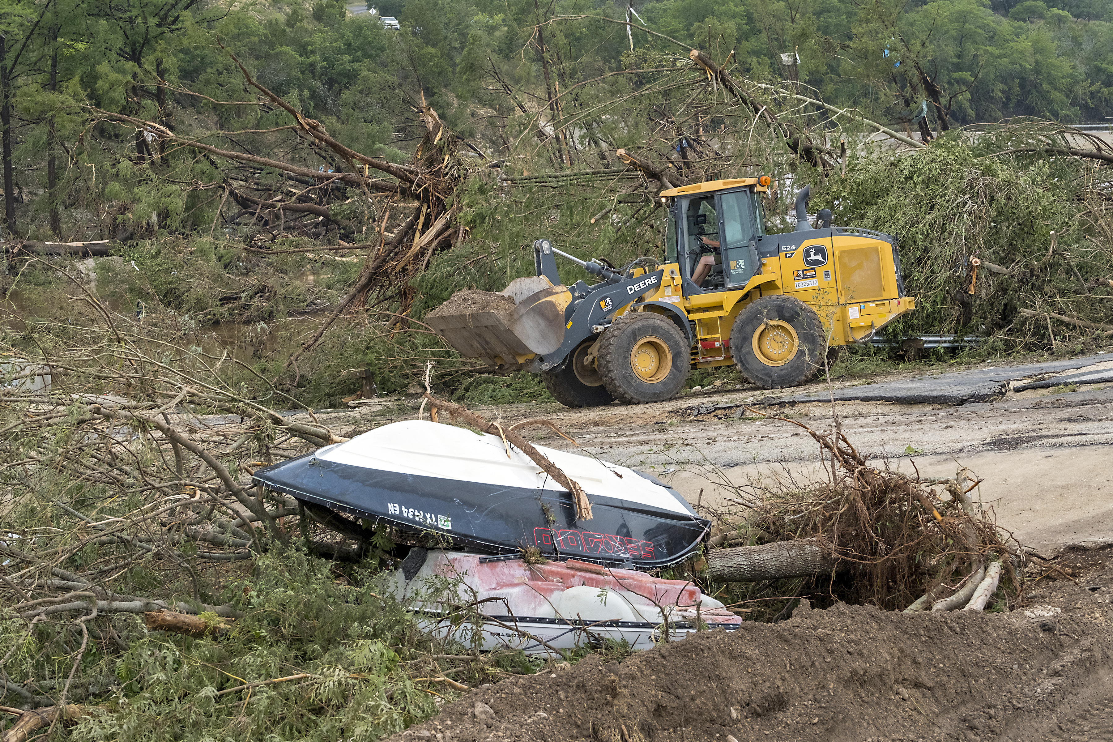 Crews work to clear debris from the Cade Loop bridge along the Guadalupe River on Saturday, July 5, 2025, in Ingram, Texas. (AP Photo/Rodolfo Gonzalez)