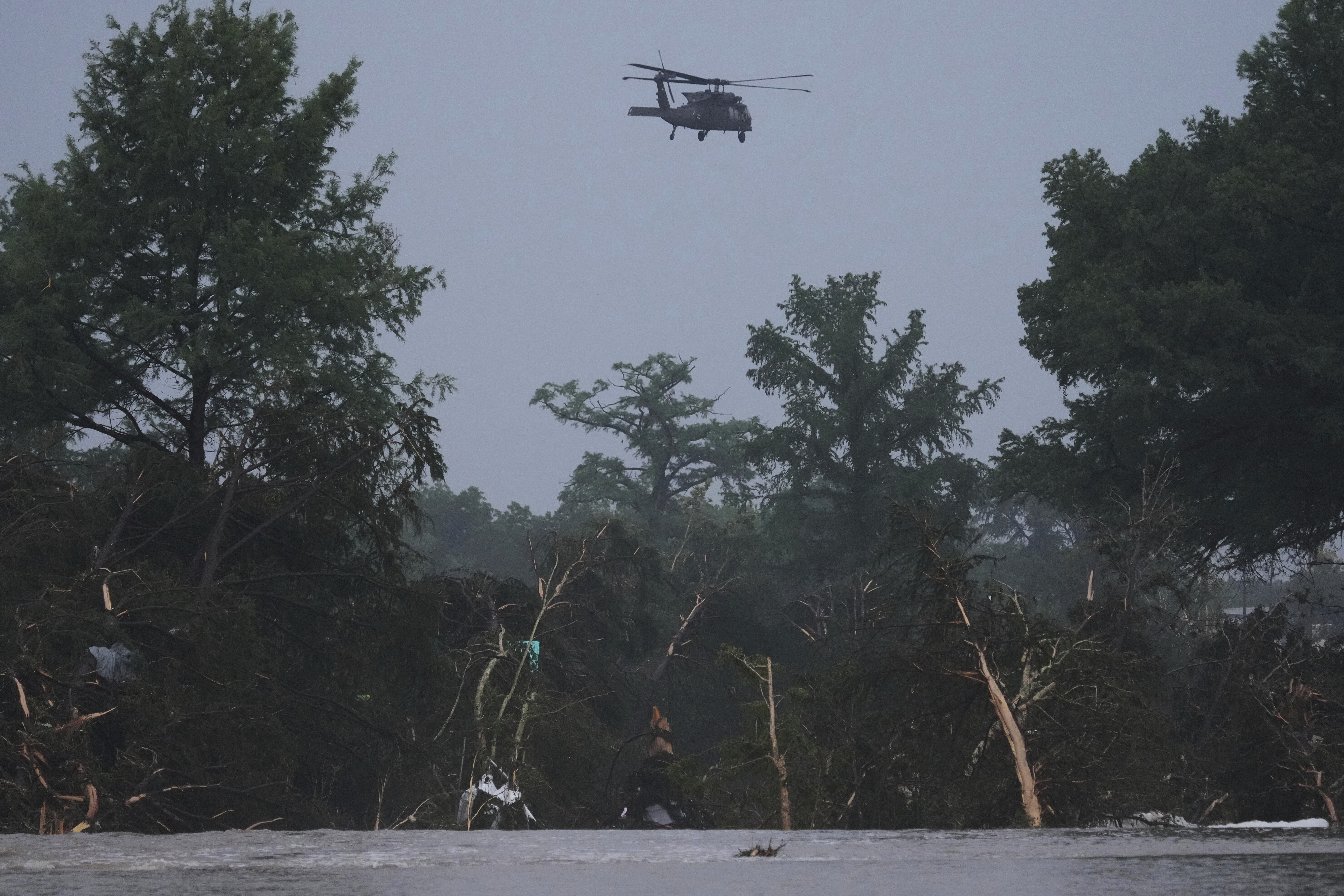 A helicopter flies over the Guadalupe River after a flash flood swept through the area, Friday, July 4, 2025, in Kerrville, Texas. (AP Photo/Eric Gay)