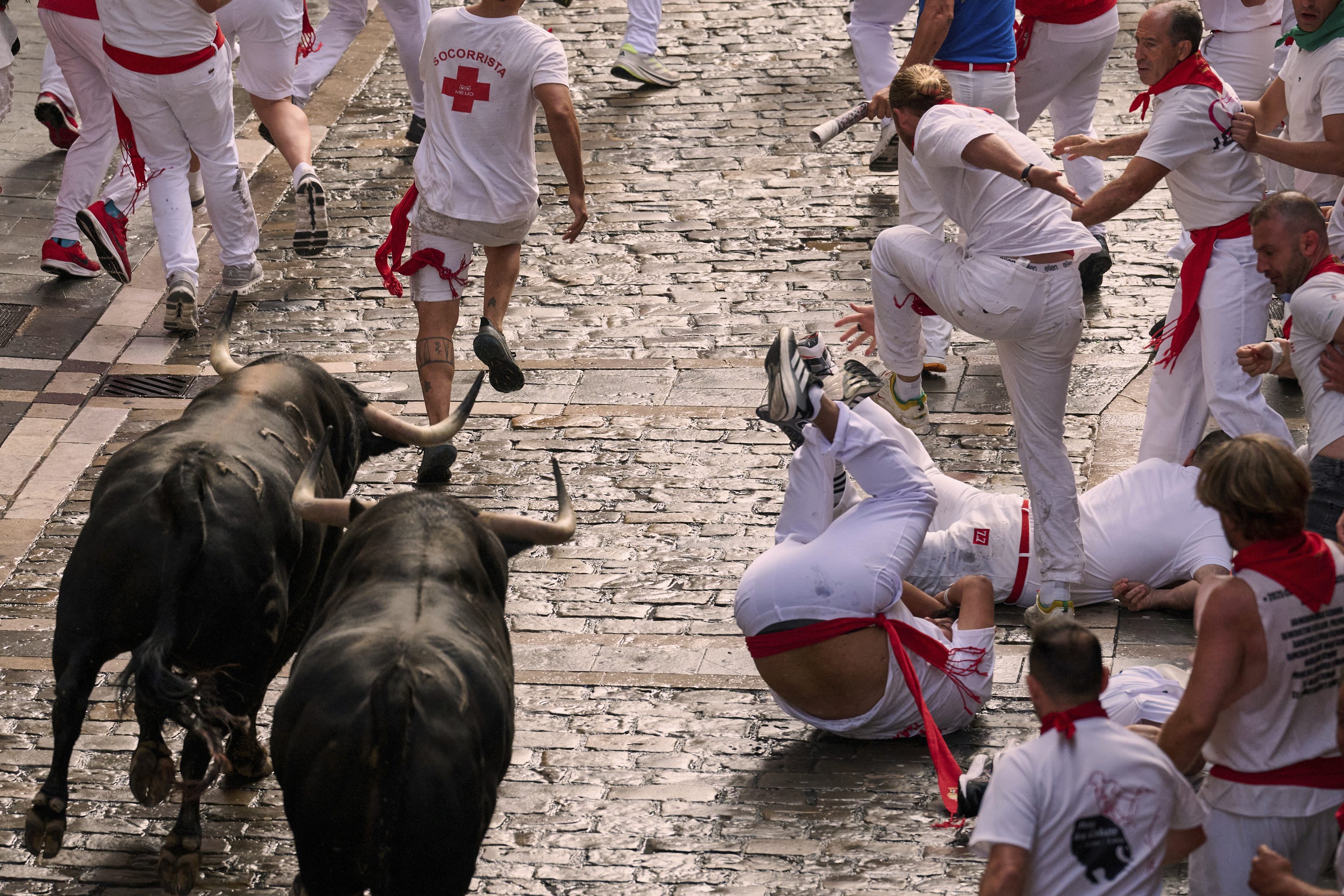 Revelers run with bulls from Fuente Ymbro ranch during the first day of the running of the bulls at the San Fermín fiestas in Pamplona, Spain, Monday, July 7, 2025. (AP Photo/Miguel Oses)