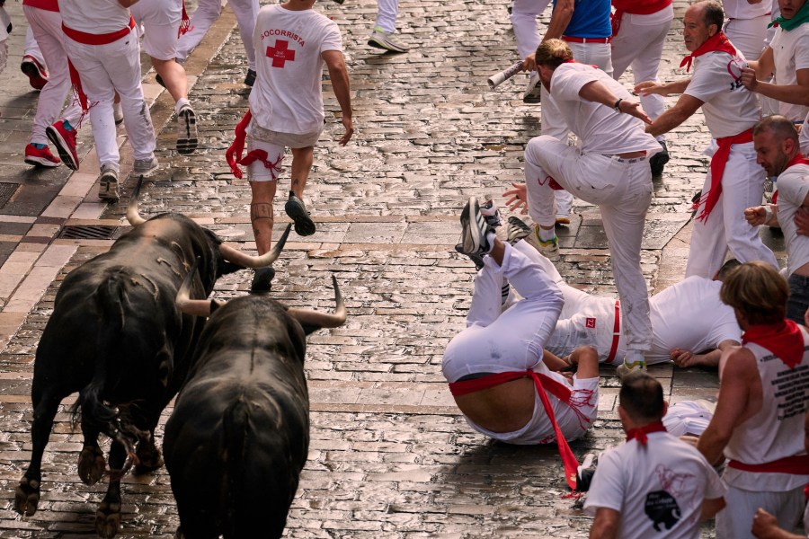 Revelers run with bulls from Fuente Ymbro ranch during the first day of the running of the bulls at the San Fermín fiestas in Pamplona, Spain, Monday, July 7, 2025. (AP Photo/Miguel Oses)