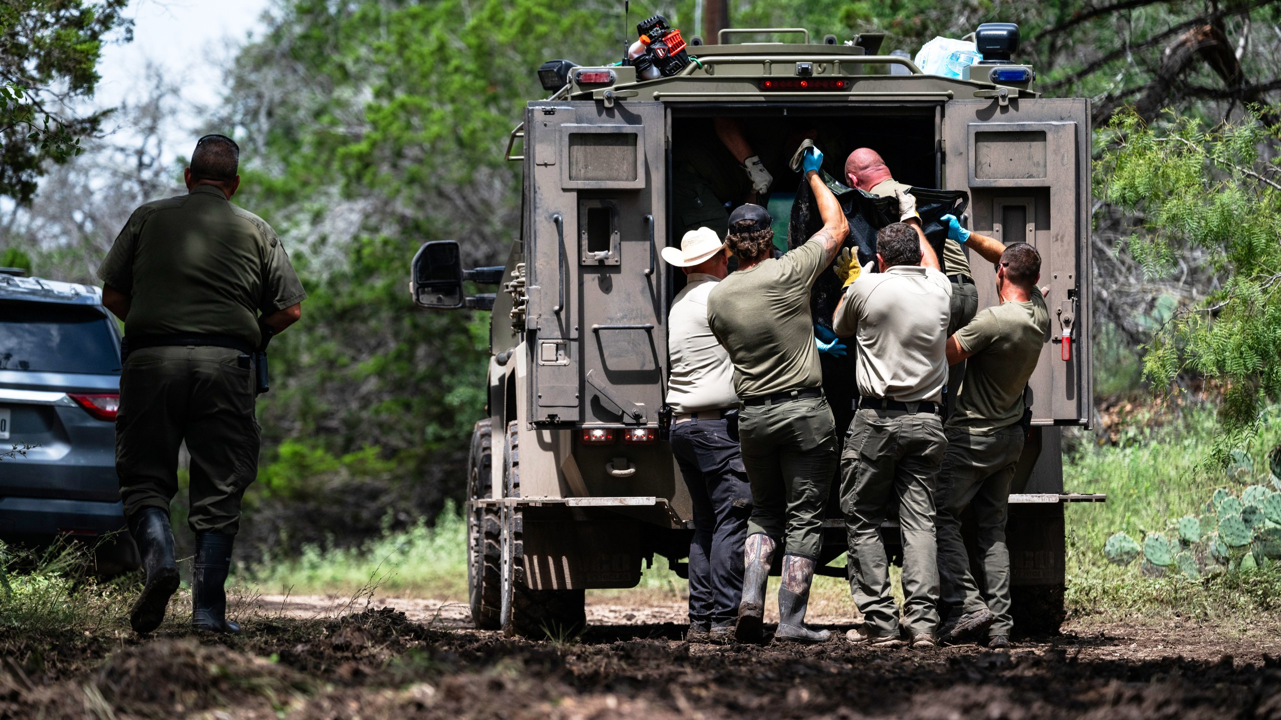 Texas Department of Public Safety Troopers load a recovered body into the back of a vehicle near the Guadalupe River after a flash flood swept through the area, Monday, July 7, 2025, in Ingram, Texas. (AP Photo/Eli Hartman)