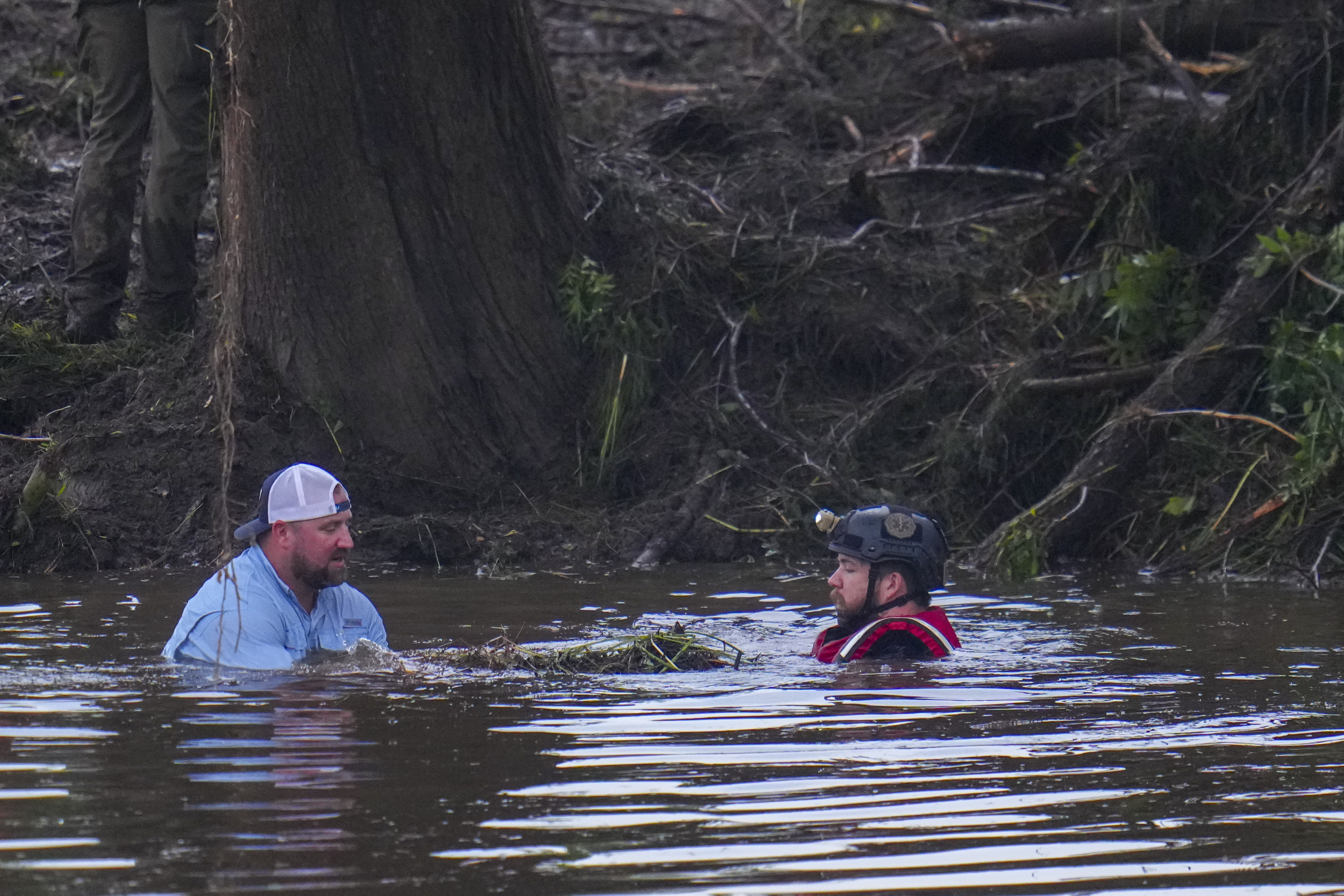 Officials are seen in the Guadalupe River as they assist in recovery efforts after a flash flood swept through the area Sunday, July 6, 2025, in Hunt, Texas. (AP Photo/Julio Cortez)