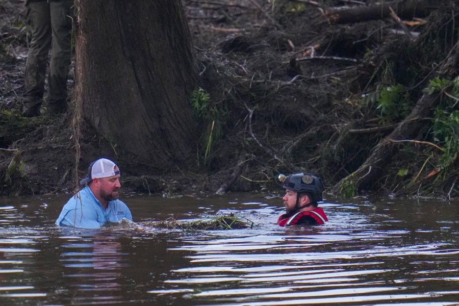 Officials are seen in the Guadalupe River as they assist in recovery efforts after a flash flood swept through the area Sunday, July 6, 2025, in Hunt, Texas. (AP Photo/Julio Cortez)