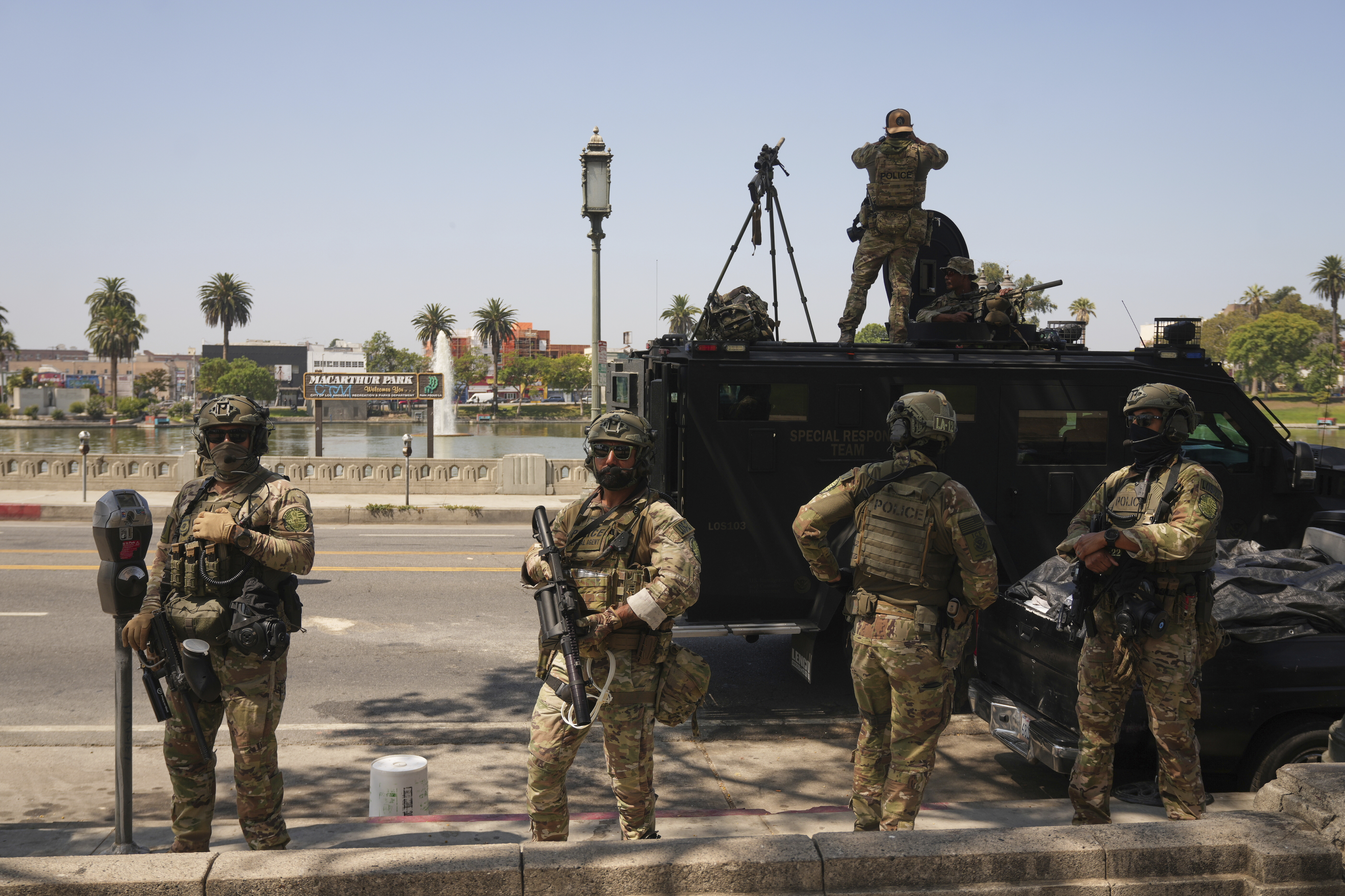 Federal agents stage at MacArthur Park Monday, July 7, 2025, in Los Angeles. (AP Photo/Damian Dovarganes)