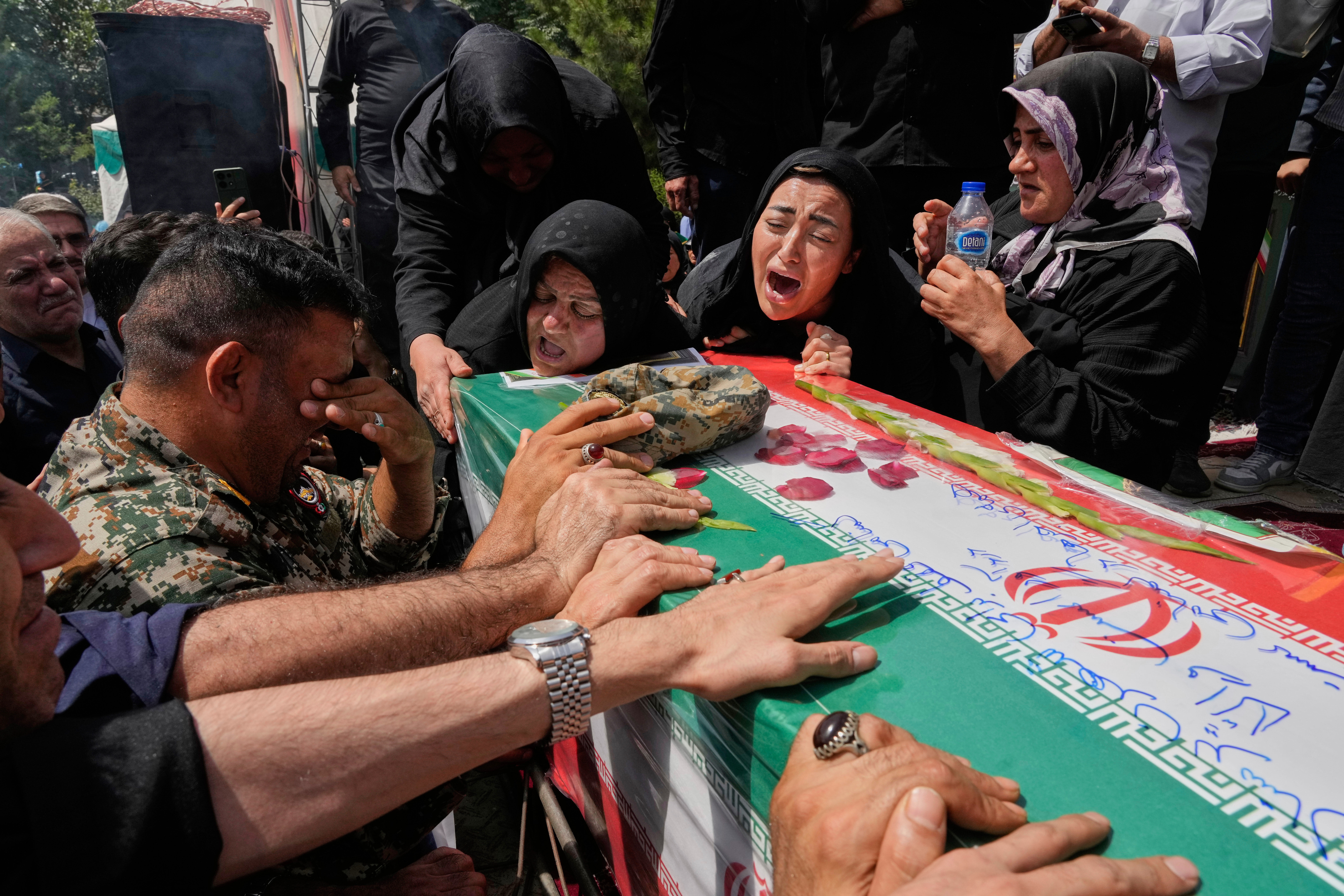 Relatives mourn over the flag-draped coffin of Mahan Setareh, a member of the paramilitary Basij force who was killed in Israeli attacks, during his funeral ceremony in Tehran, Iran, Thursday, June 26, 2025. (AP Photo/Vahid Salemi)
