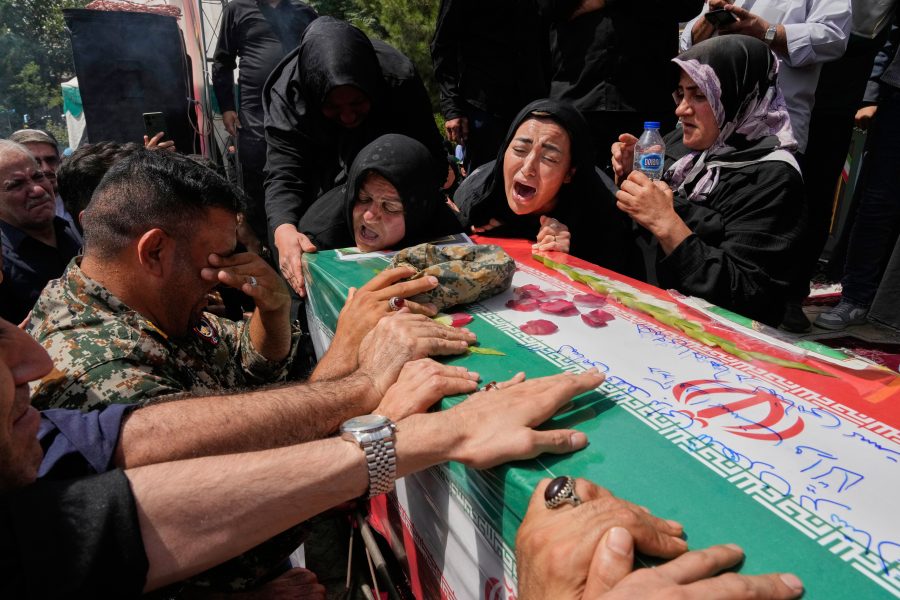 Relatives mourn over the flag-draped coffin of Mahan Setareh, a member of the paramilitary Basij force who was killed in Israeli attacks, during his funeral ceremony in Tehran, Iran, Thursday, June 26, 2025. (AP Photo/Vahid Salemi)