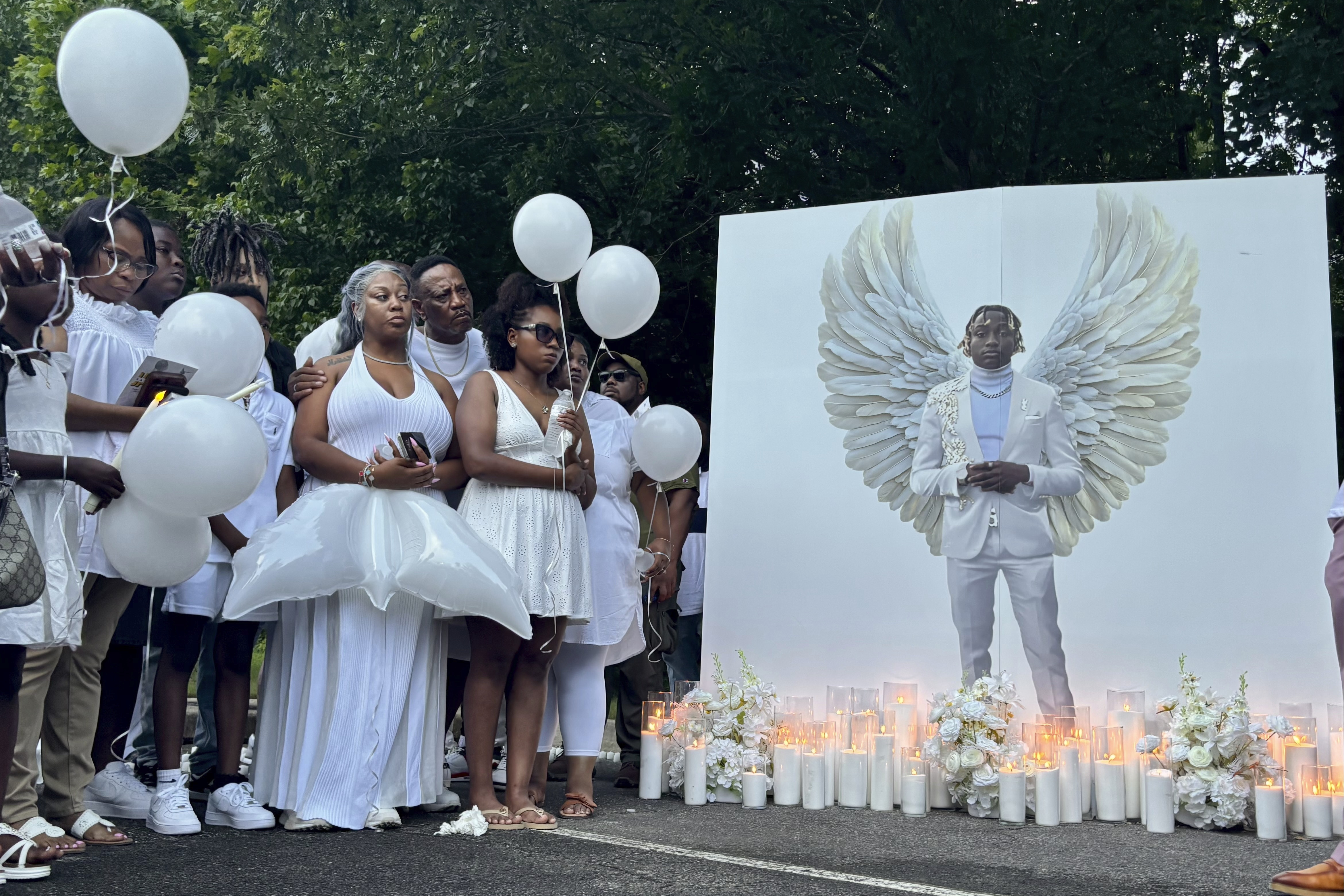 Family members of Jabari Peoples hold balloons at a candlelight vigil in Homewood, Ala., Monday, June 30, 2025. Peoples, 18, was shot and killed by police at the spot at a Homewood soccer field complex on Monday, June 23. (AP Photo/Kim Chandler)