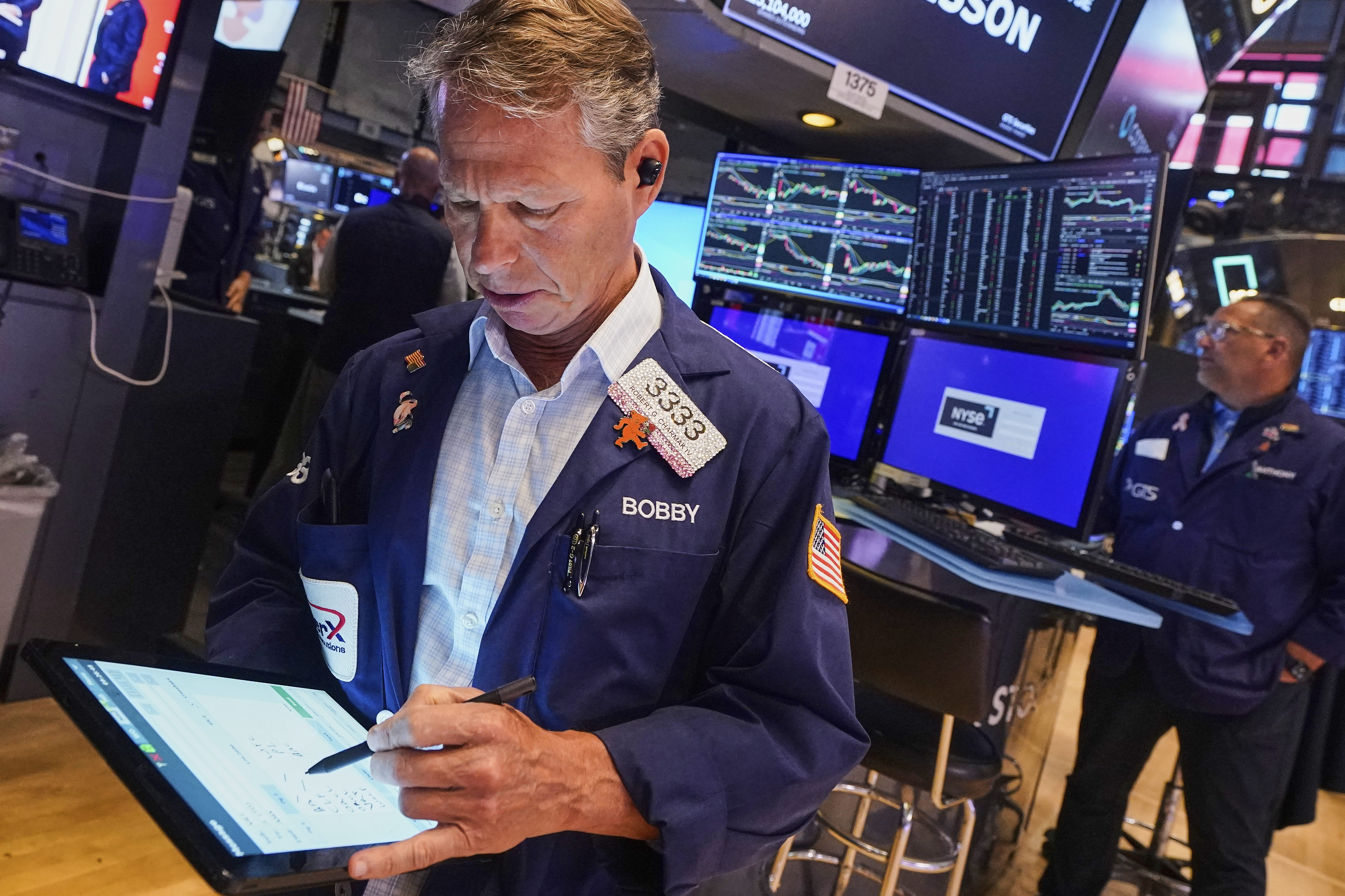 Trader Robert Charmak, left, works on the floor of the New York Stock Exchange, Tuesday, July 8, 2025. (AP Photo/Richard Drew)