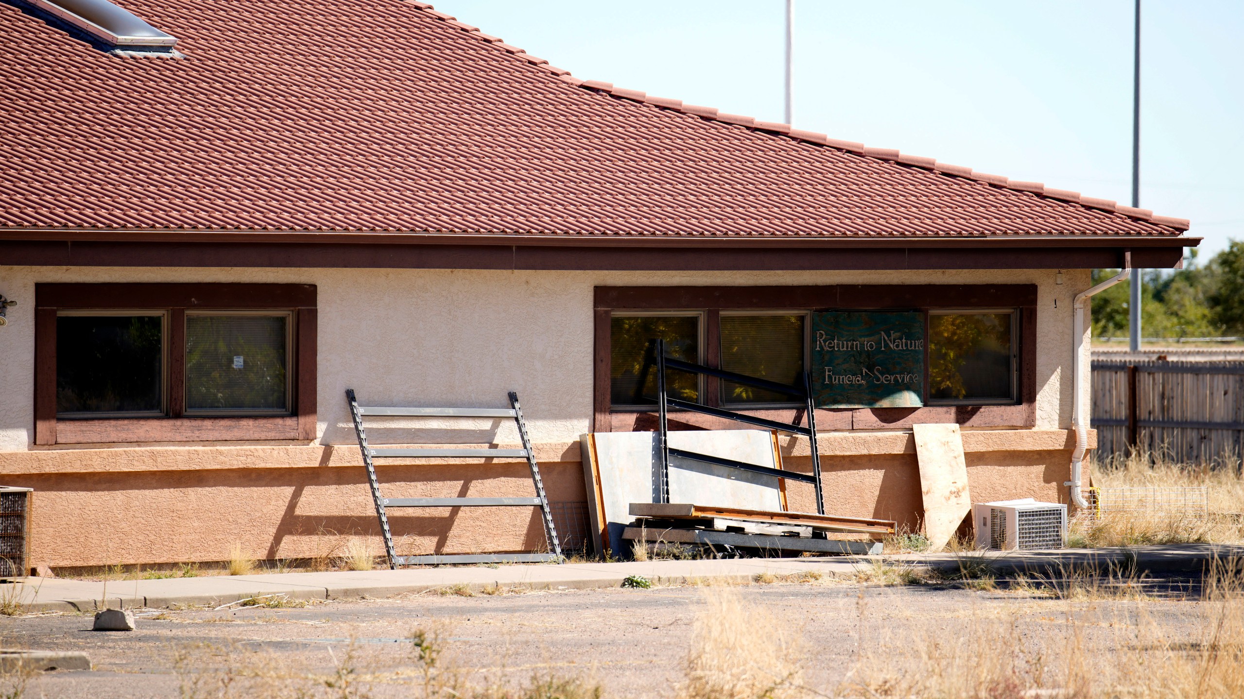 FILE - A sign covers the broken back window of the Return to Nature Funeral Home in Penrose, Colo., Oct. 16, 2023. (AP Photo/David Zalubowski, File)