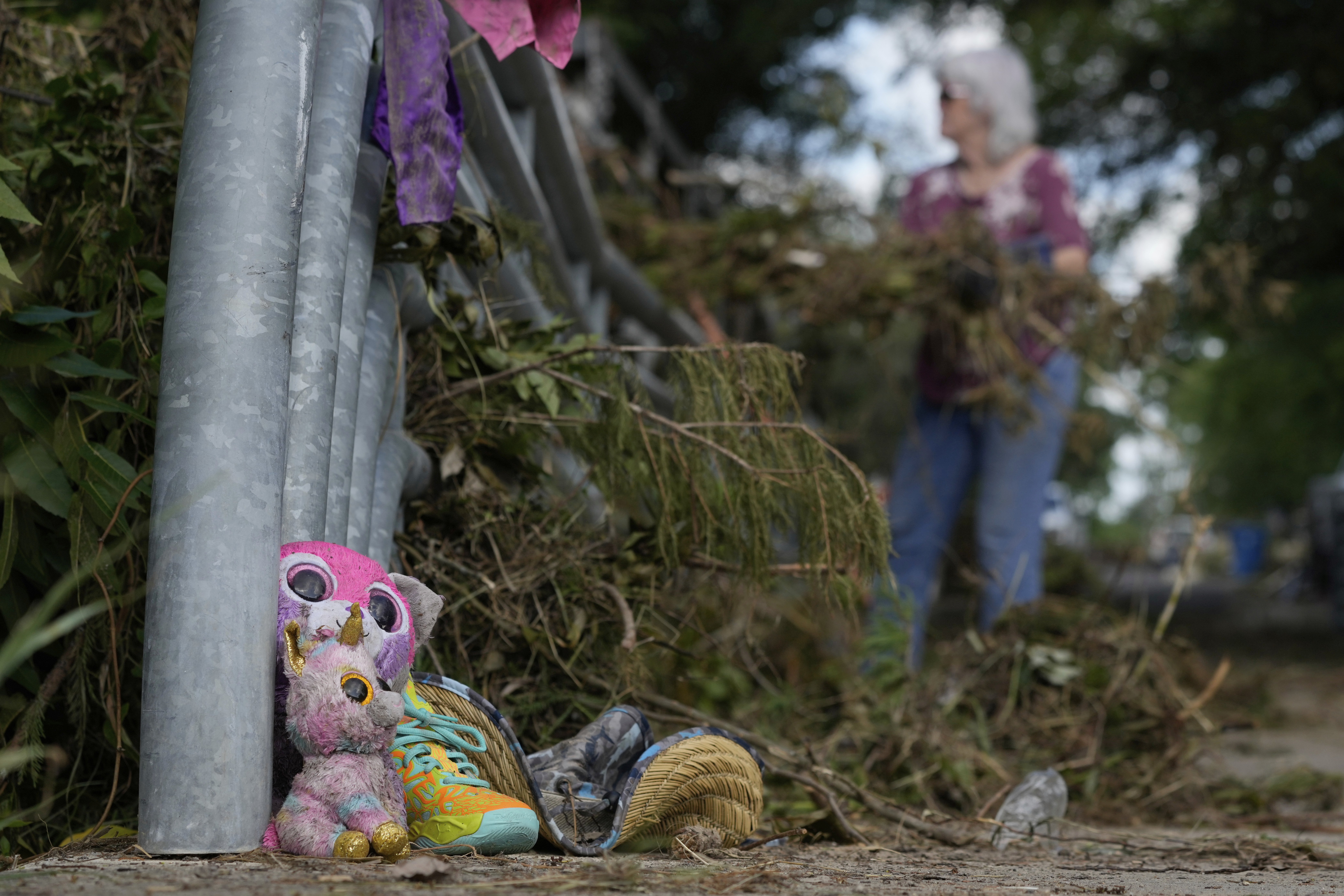 Lost items sit at a bridge as a volunteer cleans up debris on Tuesday, July 8, 2025, after a flash flood swept through the area in Kerrville, Texas. (AP Photo/Ashley Landis)