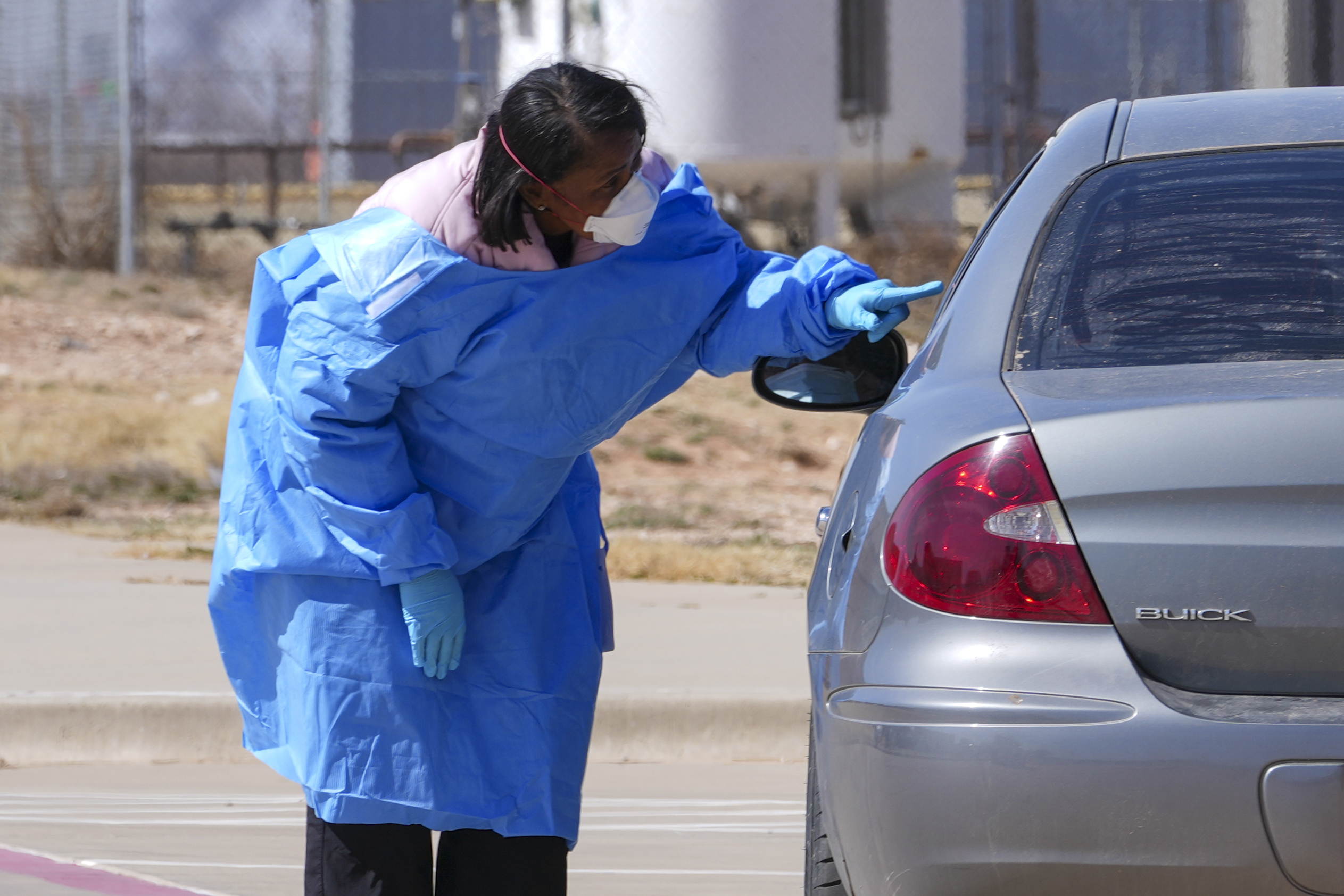 FILE - A health worker talks to people before administering measles tests outside Seminole Hospital District, Feb. 21, 2025, in Seminole, Texas. (AP Photo/Julio Cortez, File)