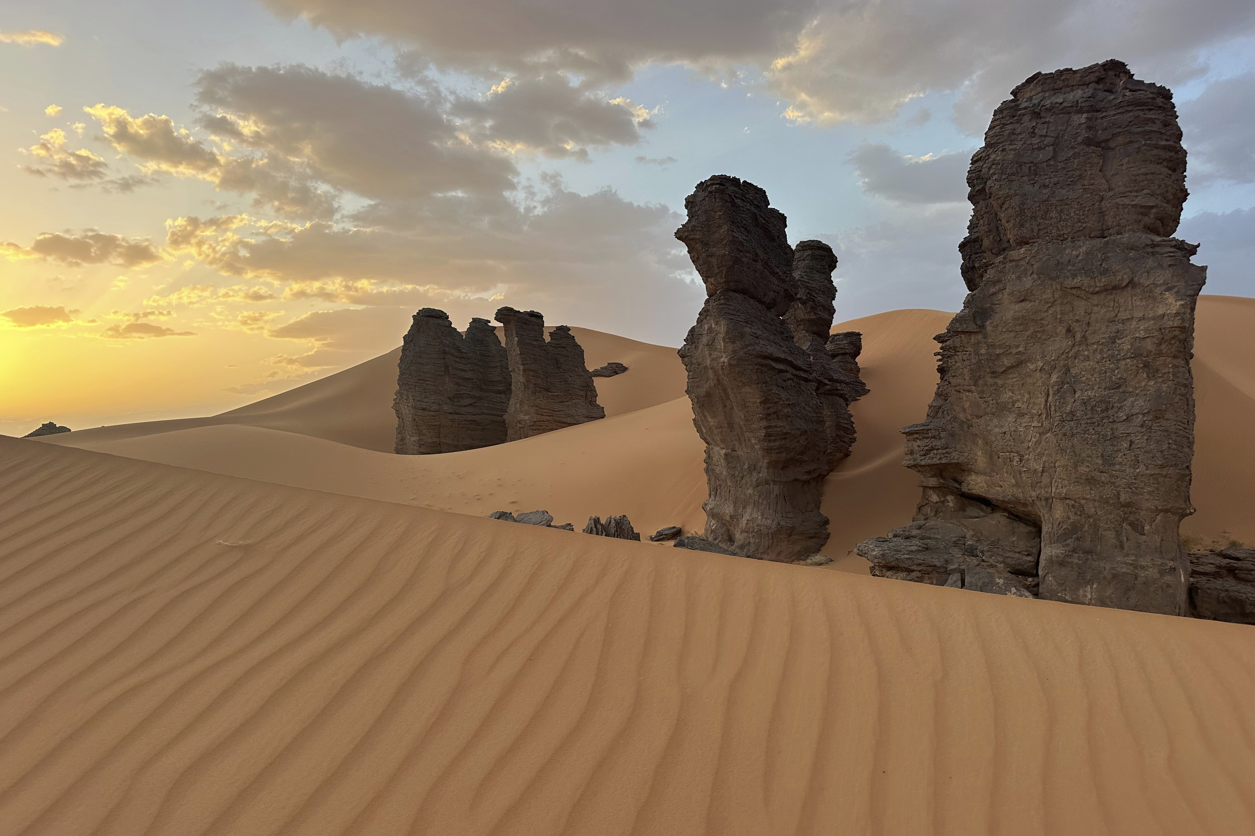 Rock formations stand in the Sahara desert outside the city center of Djanet, a southeastern Algerian oasis town in the Sahara desert, on July 5, 2025. (AP Photo/Audrey Thibert)