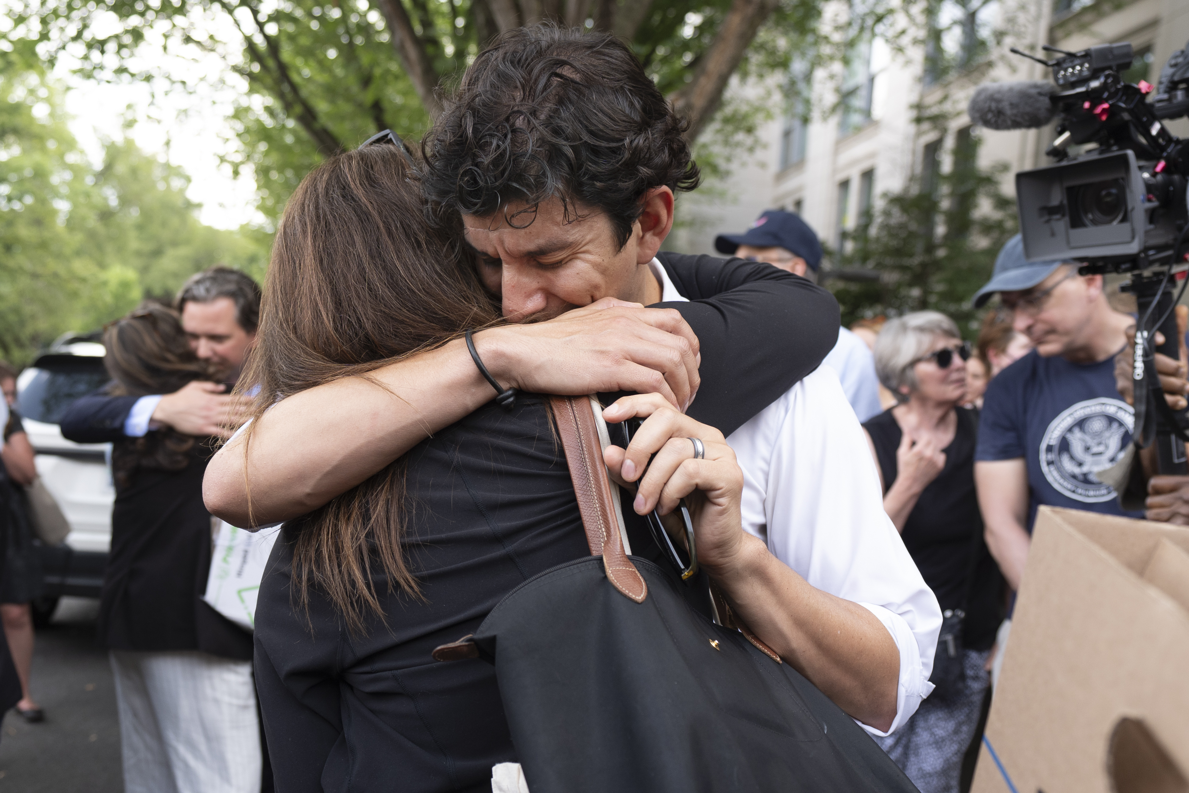 A fired State Department employee, left, is greeted outside of the Harry S. Truman Building, the headquarters of the State Department, in Washington, Friday, July 11, 2025. (AP Photo/Manuel Balce Ceneta)