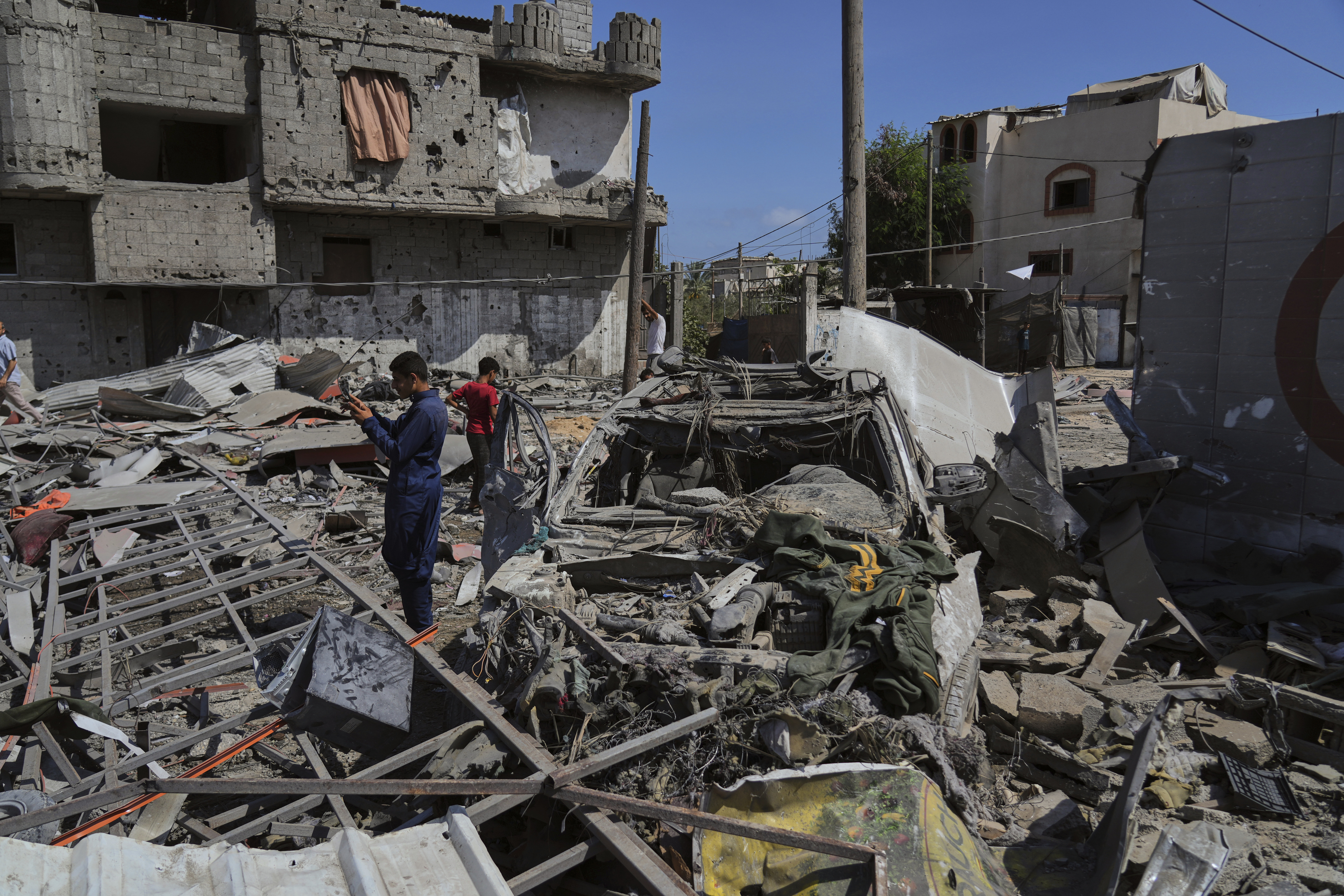 Palestinians inspect the wreckage of a gas station destroyed in an Israeli airstrike in Deir al-Balah, central Gaza Strip, Saturday, July 12, 2025. (AP Photo/Abdel Kareem Hana)