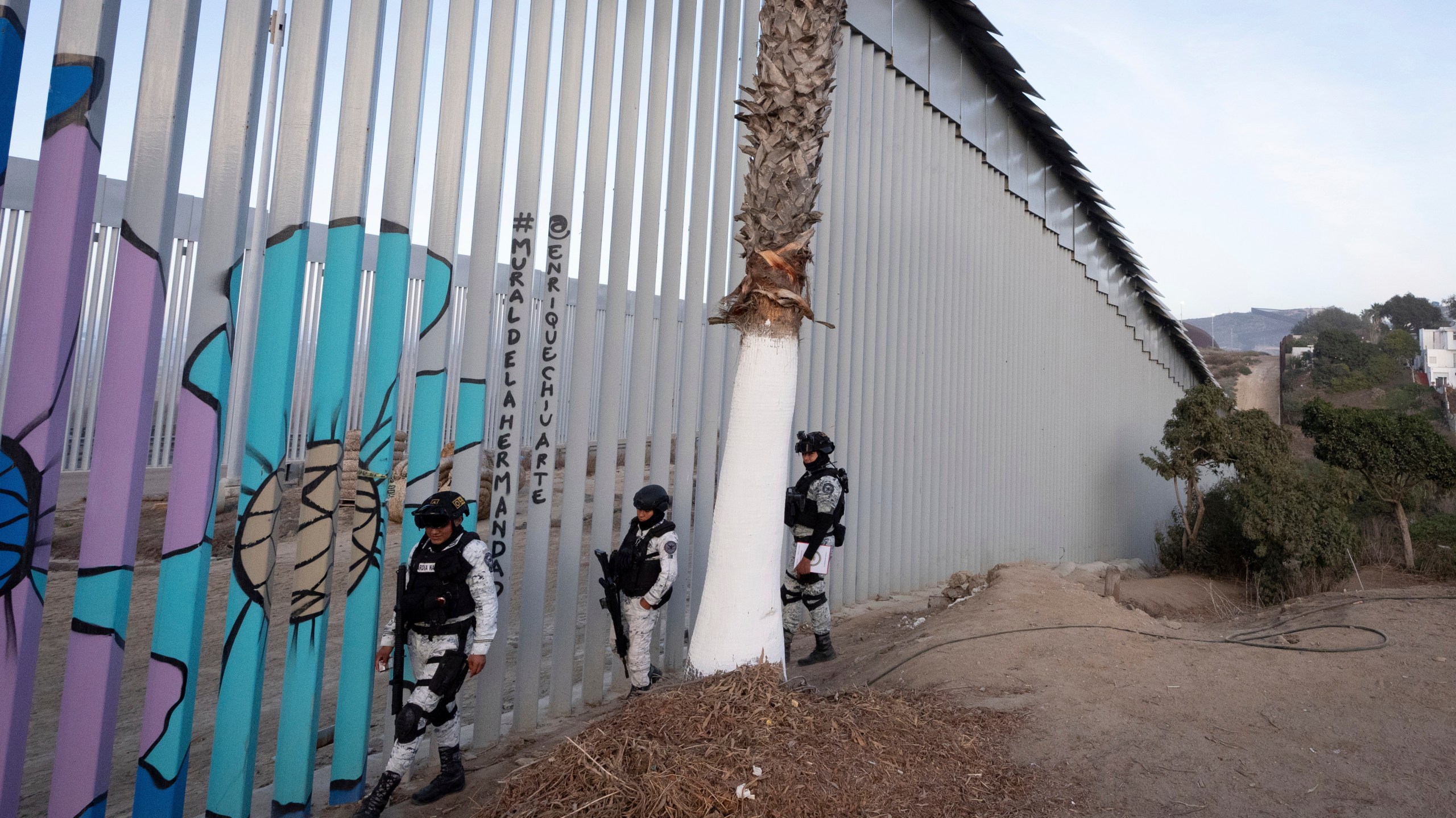 FILE - Members of the Mexican National Guard patrol along the border wall separating Mexico and the United States, in Tijuana, Jan. 20, 2025. (AP Photo/Gregory Bull, File)