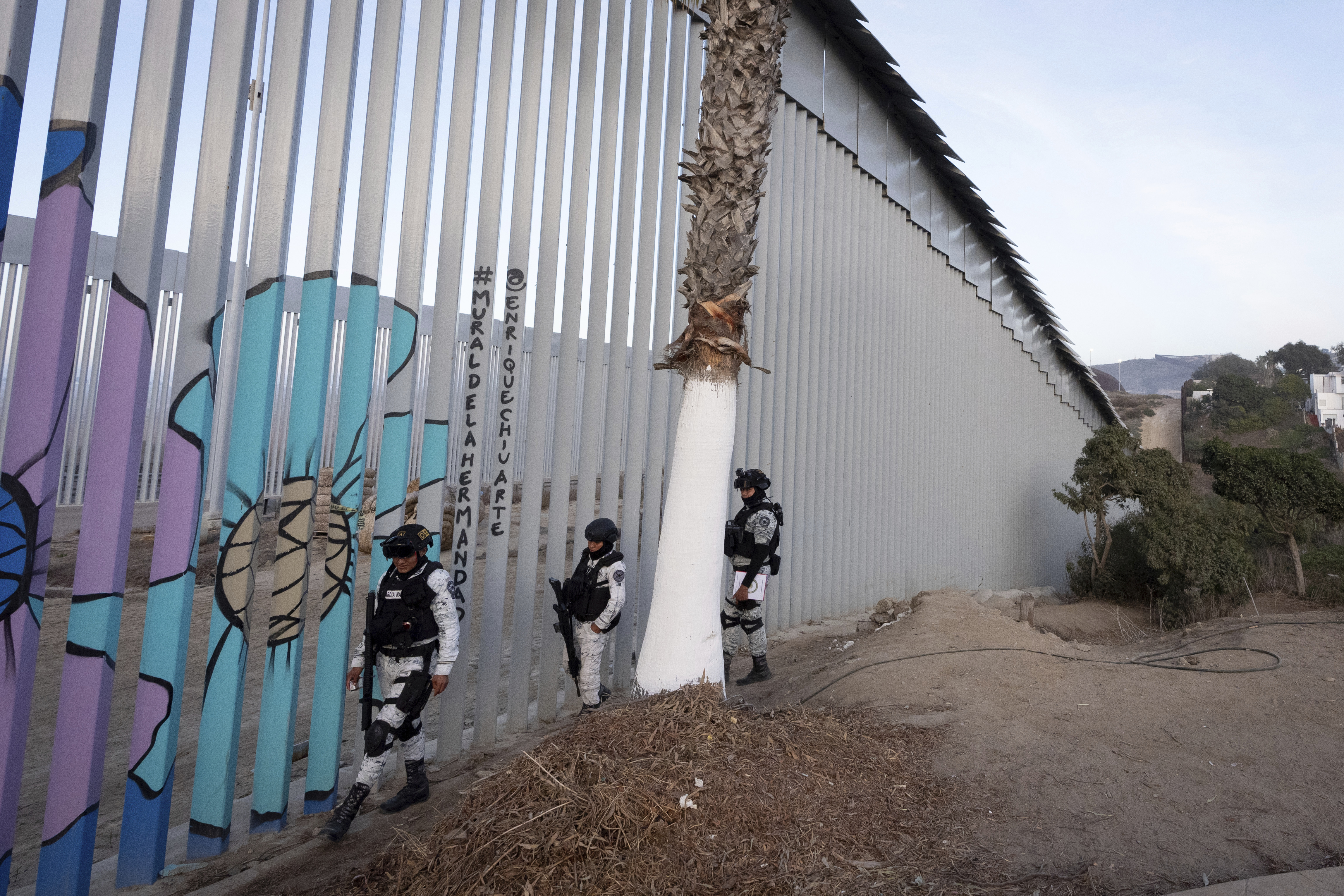 FILE - Members of the Mexican National Guard patrol along the border wall separating Mexico and the United States, in Tijuana, Jan. 20, 2025. (AP Photo/Gregory Bull, File)
