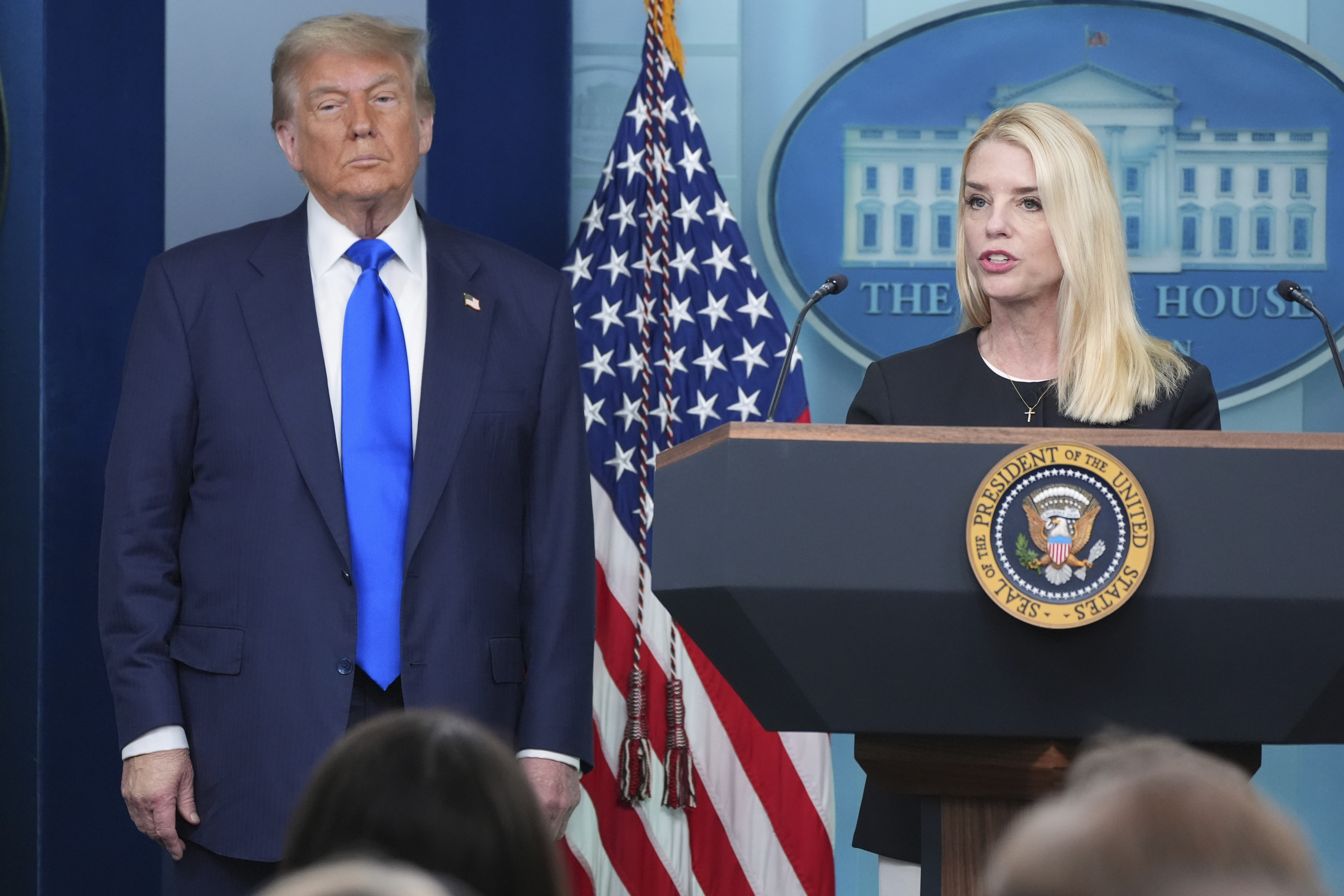 Attorney General Pam Bondi speaks to reporters as President Donald Trump listens, Friday, June 27, 2025, in the briefing room of the White House in Washington. (AP Photo/Jacquelyn Martin)