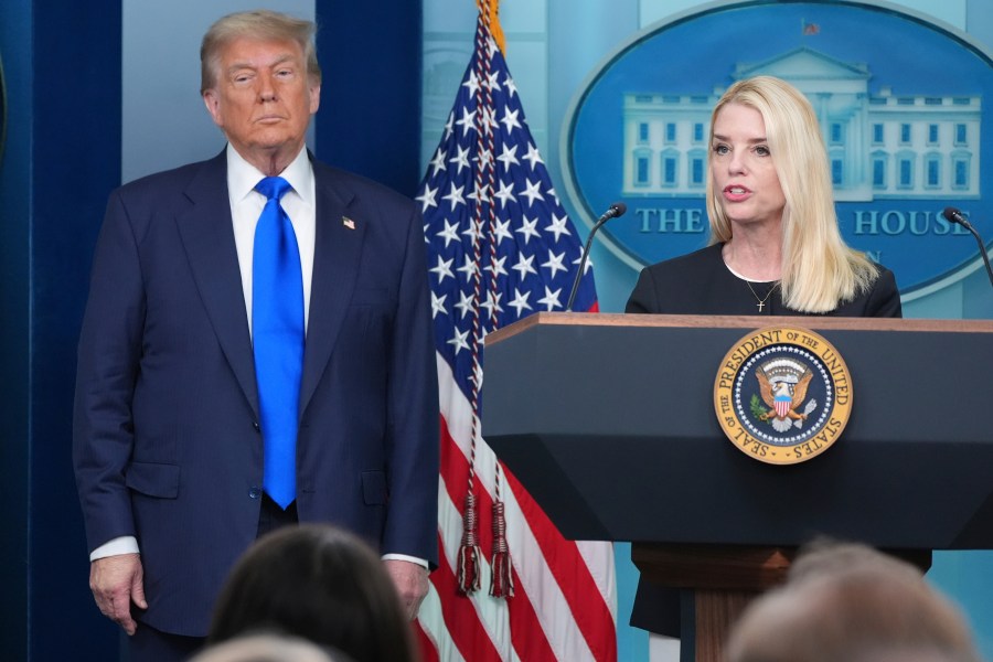 Attorney General Pam Bondi speaks to reporters as President Donald Trump listens, Friday, June 27, 2025, in the briefing room of the White House in Washington. (AP Photo/Jacquelyn Martin)