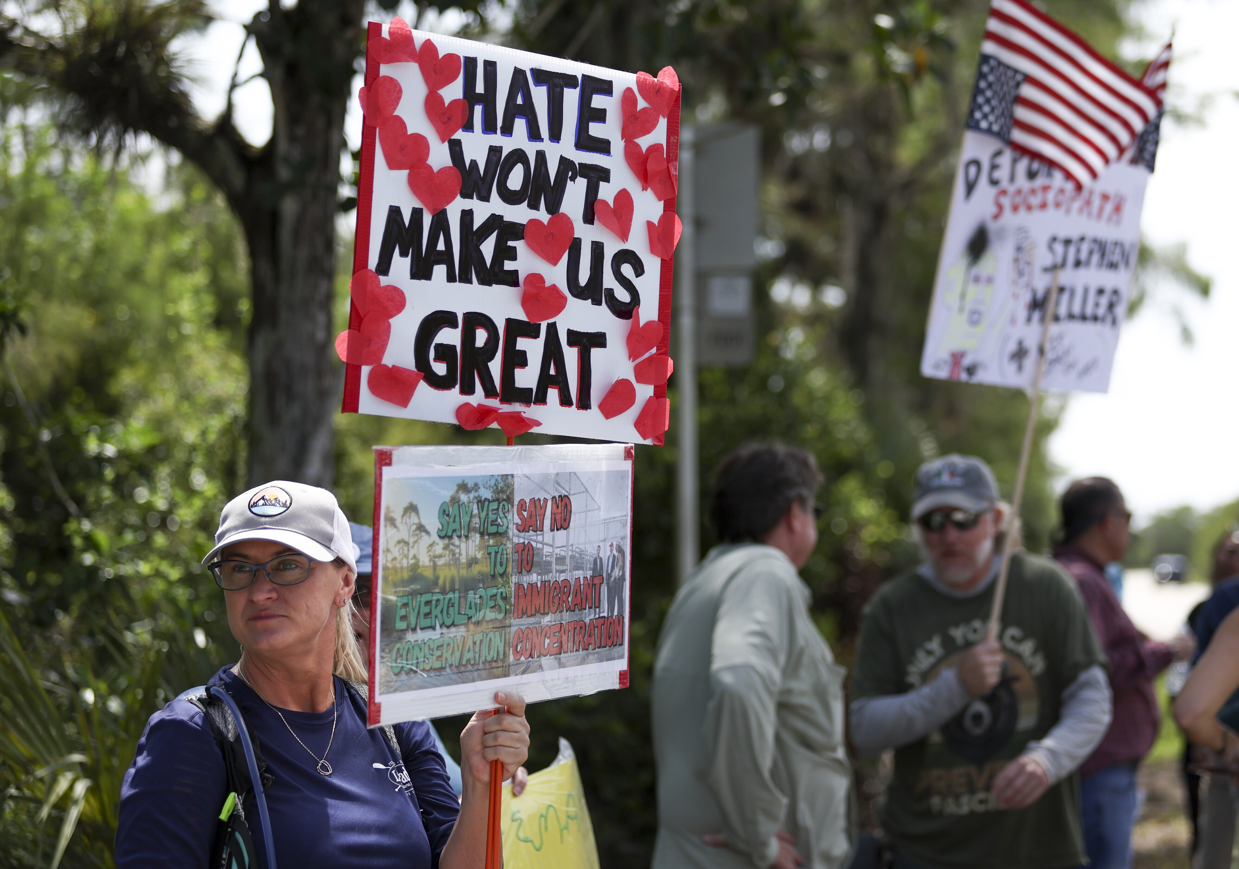 A protester stands outside the migrant detention facility dubbed "Alligator Alcatraz" at the Dade-Collier Training and Transition Facility, Saturday, July 12, 2025, in Ochopee, Fla. (AP Photo/Alexandra Rodriguez)