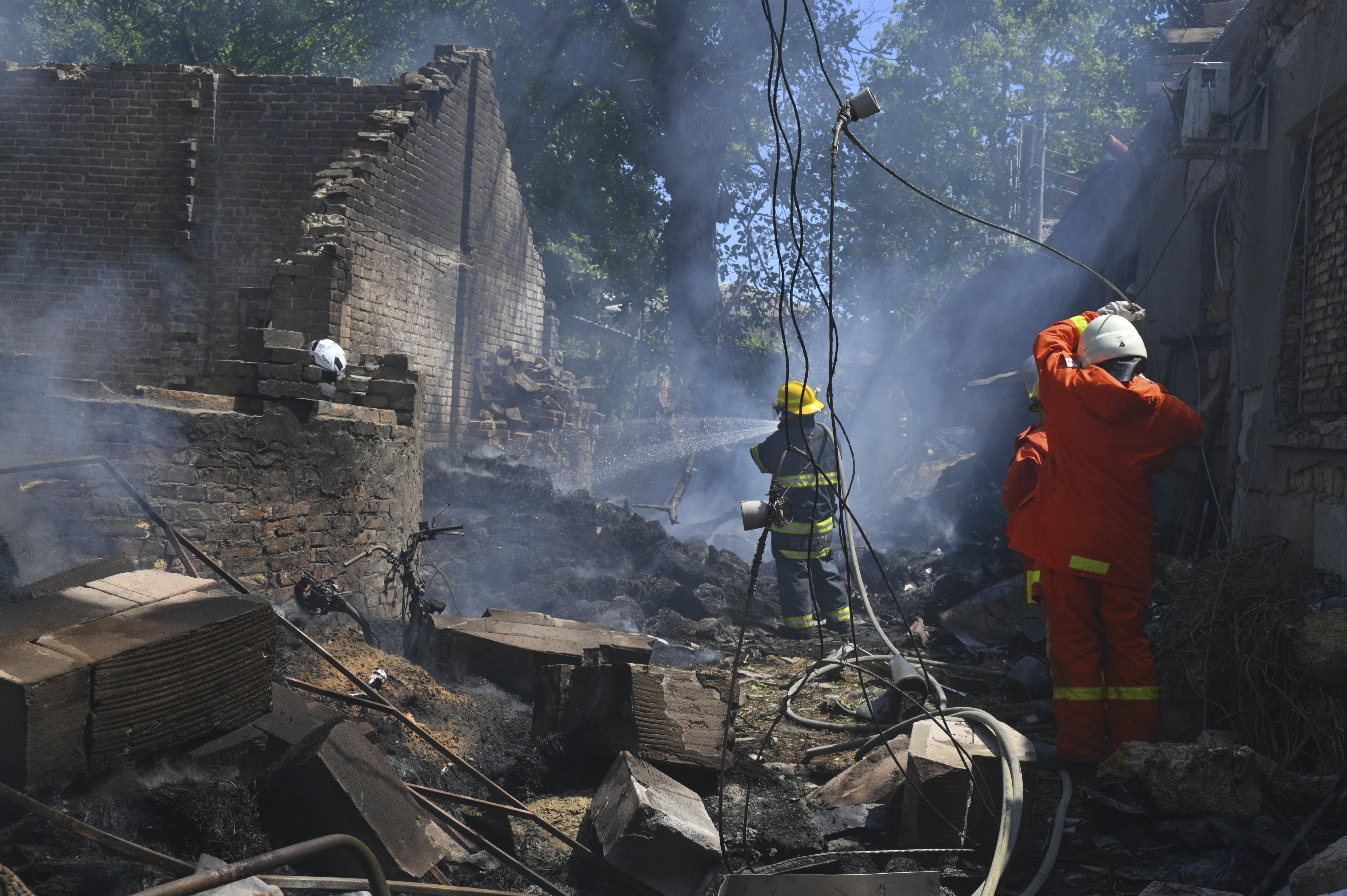 Emergency services personnel work to extinguish a fire following a Russian attack in Odesa, Ukraine, Friday, July 11, 2025. (AP Photo/Michael Shtekel)