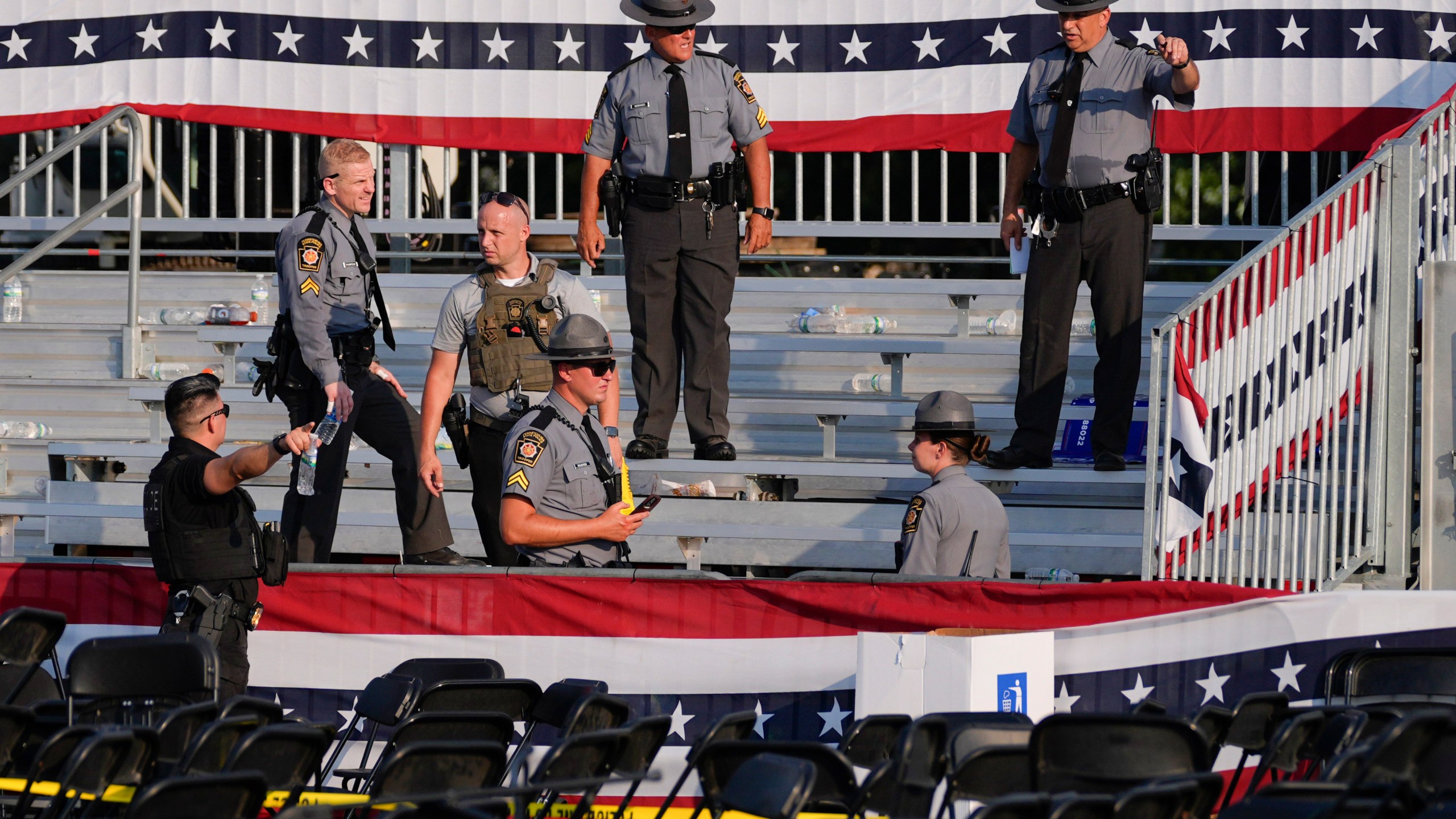 FILE - Law enforcement officers work at the campaign rally site for Republican presidential candidate former President Donald Trump that is shown empty and littered with debris, July 13, 2024, in Butler, Pa. (AP Photo/Evan Vucci, File)