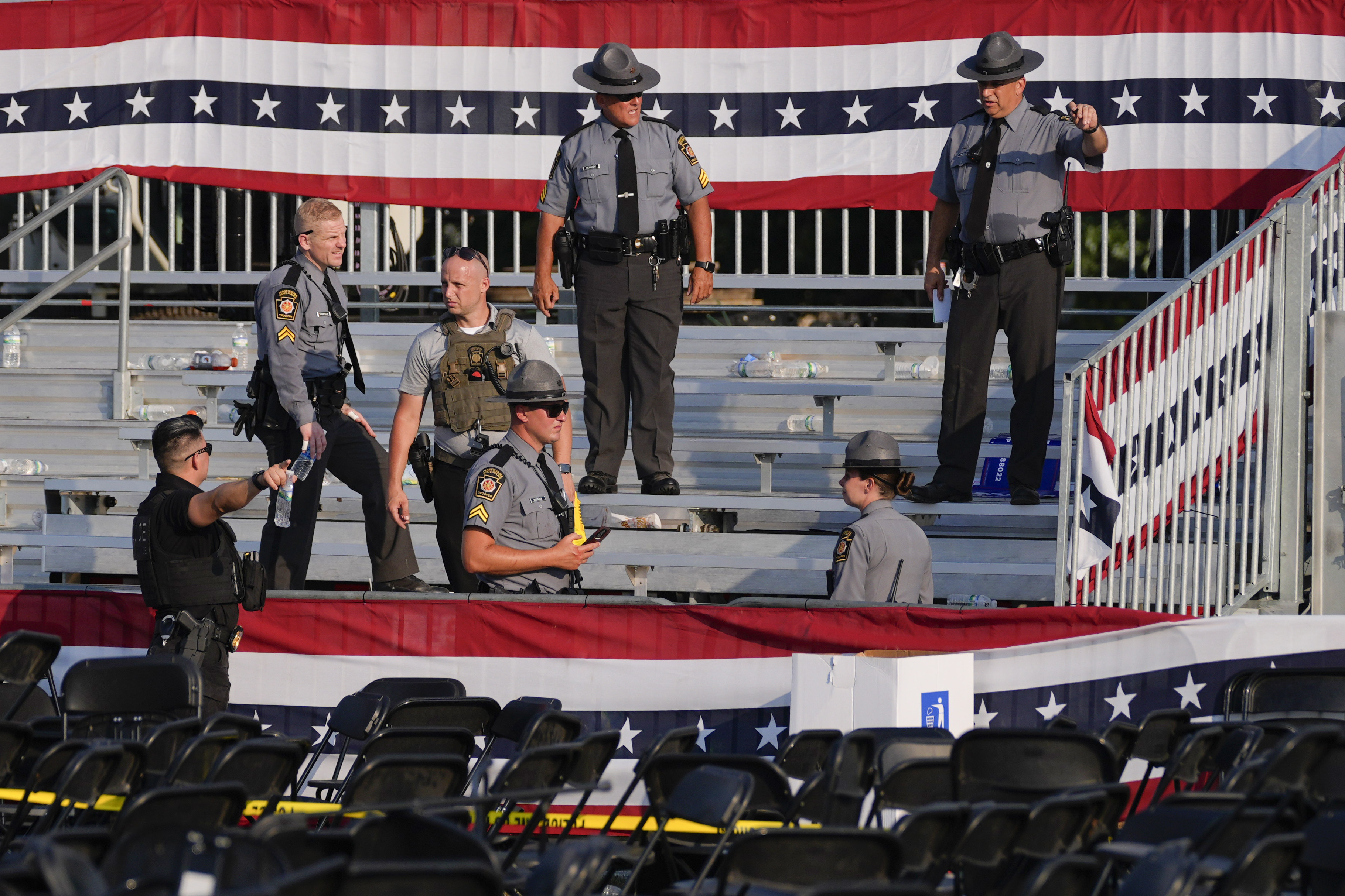 FILE - Law enforcement officers work at the campaign rally site for Republican presidential candidate former President Donald Trump that is shown empty and littered with debris, July 13, 2024, in Butler, Pa. (AP Photo/Evan Vucci, File)